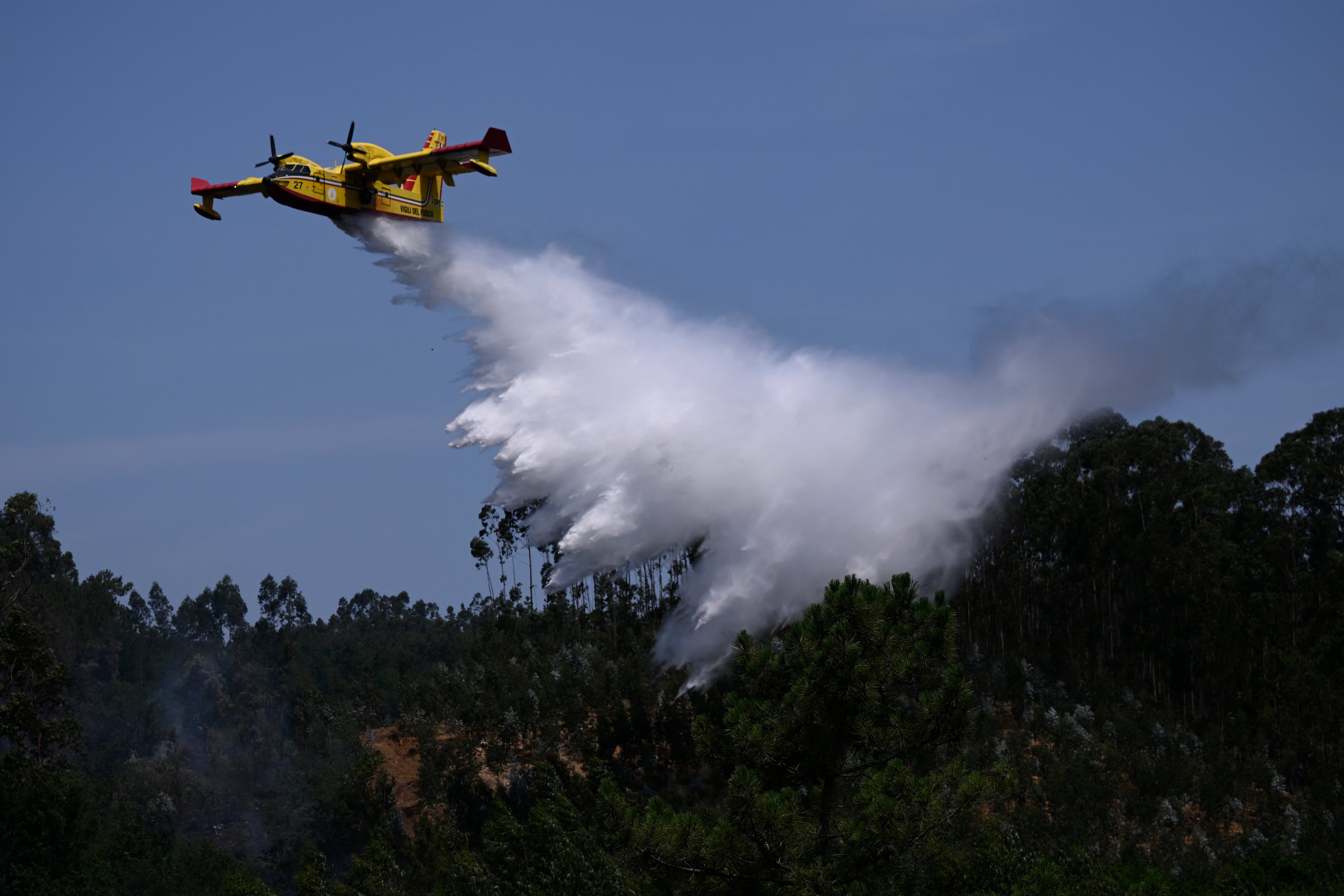 Un avión cisterna Canadair italiano lanza agua sobre un incendio forestal cerca de la localidad de São João do Monte, en el centro de Portugal, el 5 de julio del 2026.