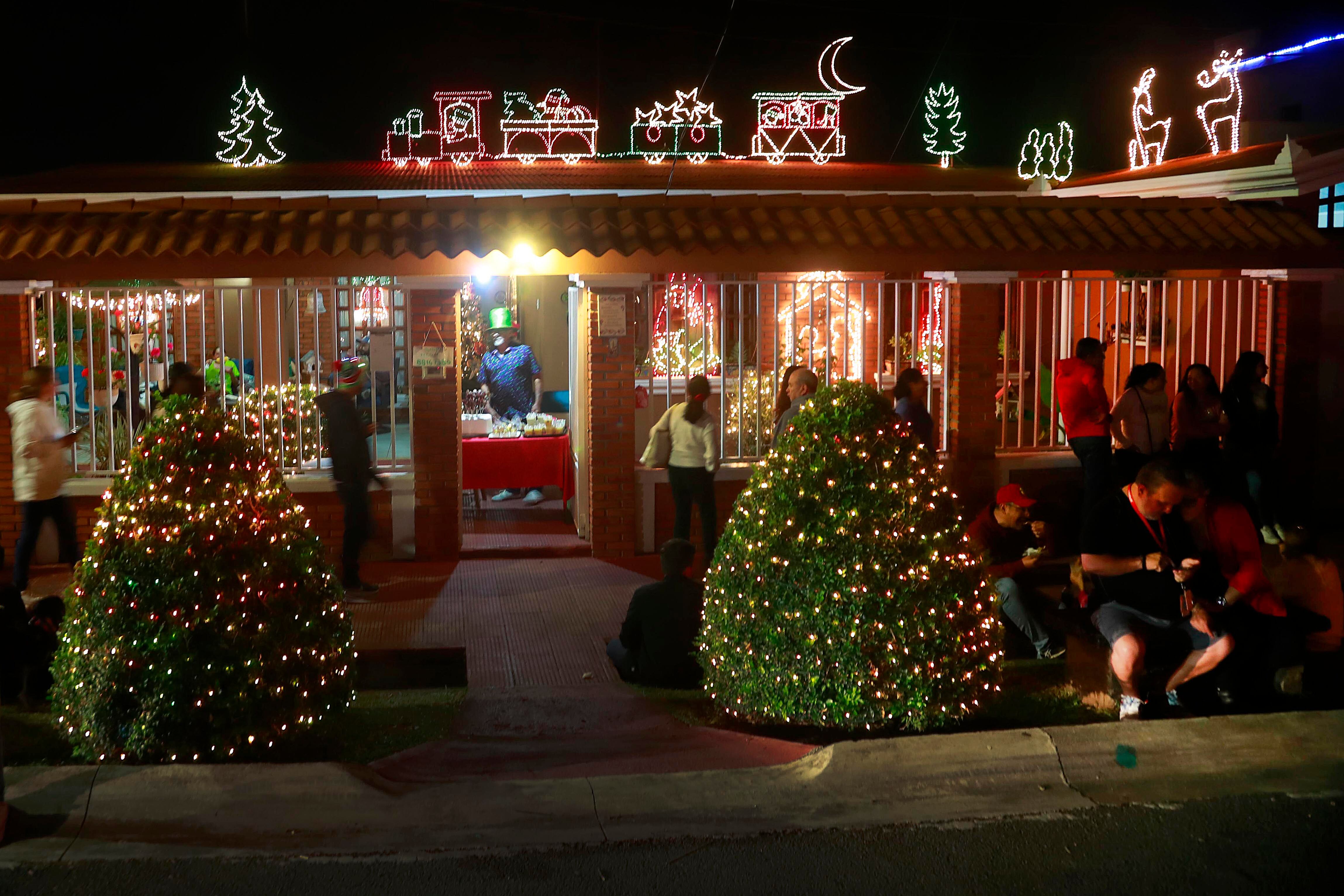 07/12/2023 San Joaquín de Flores. Vecinos de barrio La Cruz reviven la tradición de todos los años con la iluminación del frente de sus casas y árboles de las aceras, además de la venta de comidas que acerca a decenas de personas, quienes todas las noches se acercan para compartir en la calle misma y disfrutar de un verdadero ambiente navideño.