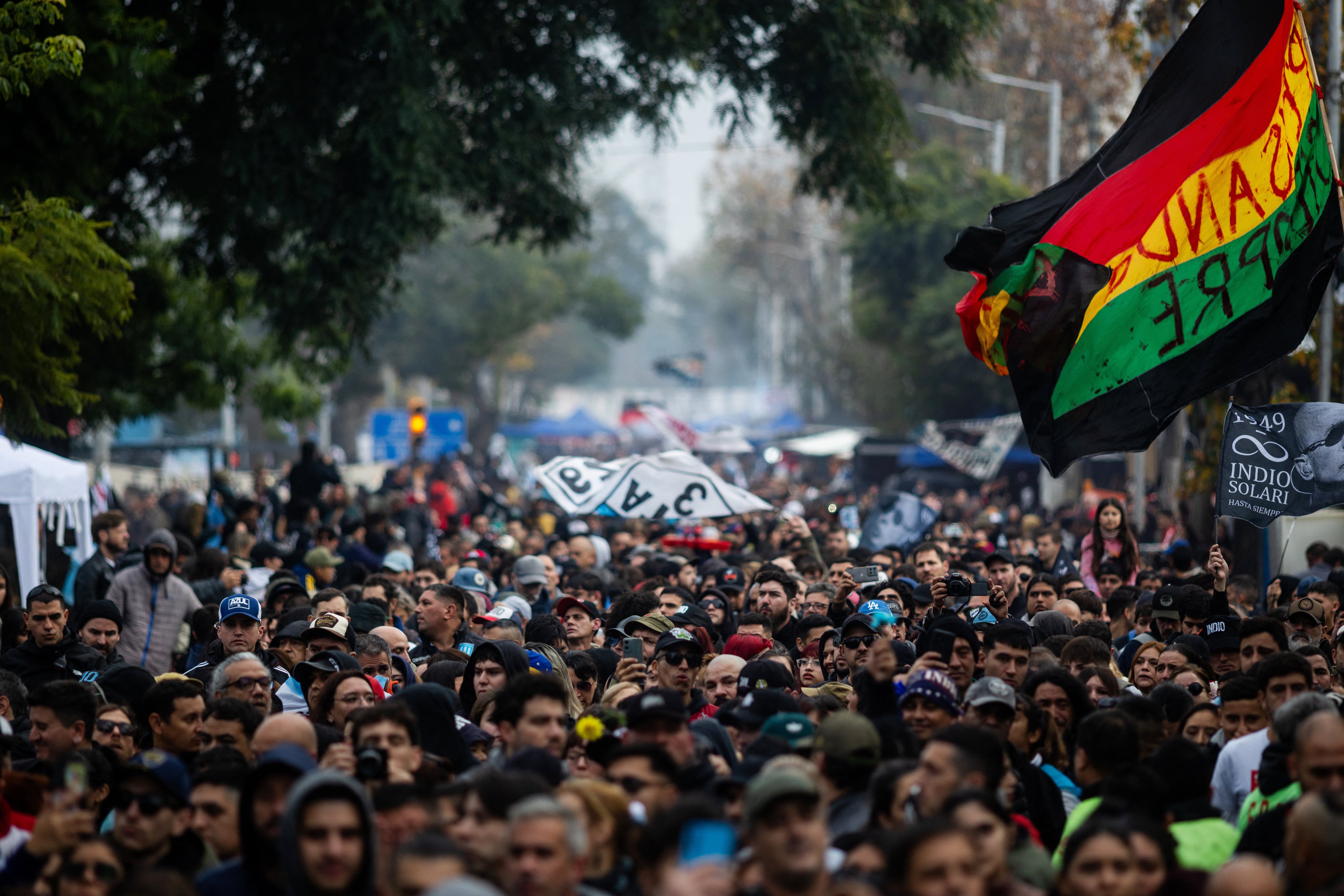 Fans wait to pay their respects to the coffin with the remains of Carlos Alberto "Indio" Solari, the iconic Argentine rock musician and former lead singer of Patricio Rey y sus Redonditos de Ricota, at Villa Dominico, Buenos Aires Province, Argentina, on June 7, 2026. The singer died in Parque Leloir, Buenos Aires Province, on June 5 at the age of 77. (Photo by Tomas CUESTA / AFP)