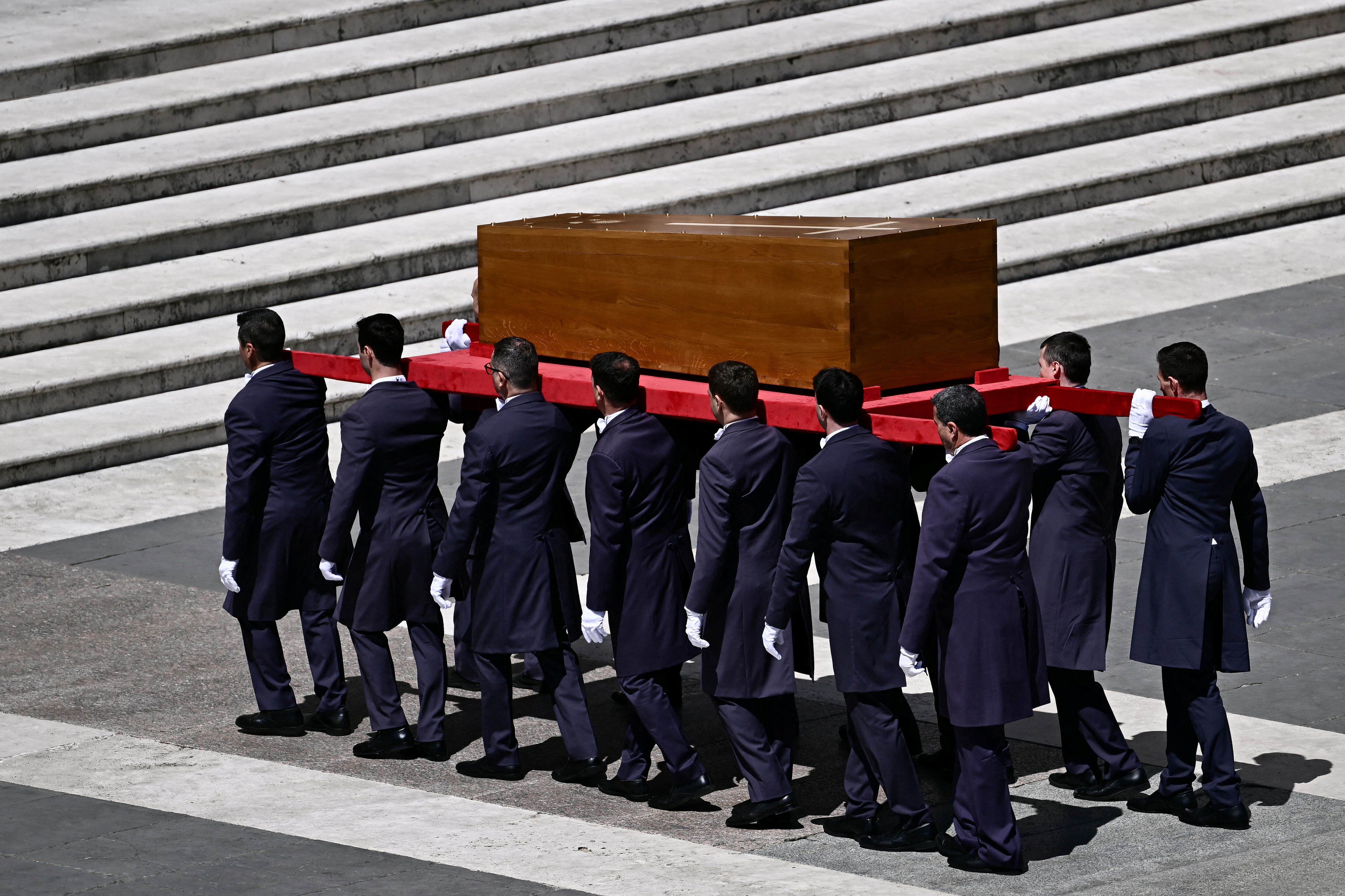Los portadores del féretro llevan el ataúd durante la ceremonia fúnebre del difunto Papa Francisco en la Plaza de San Pedro del Vaticano de vuelta a la basílica de San Pedro.