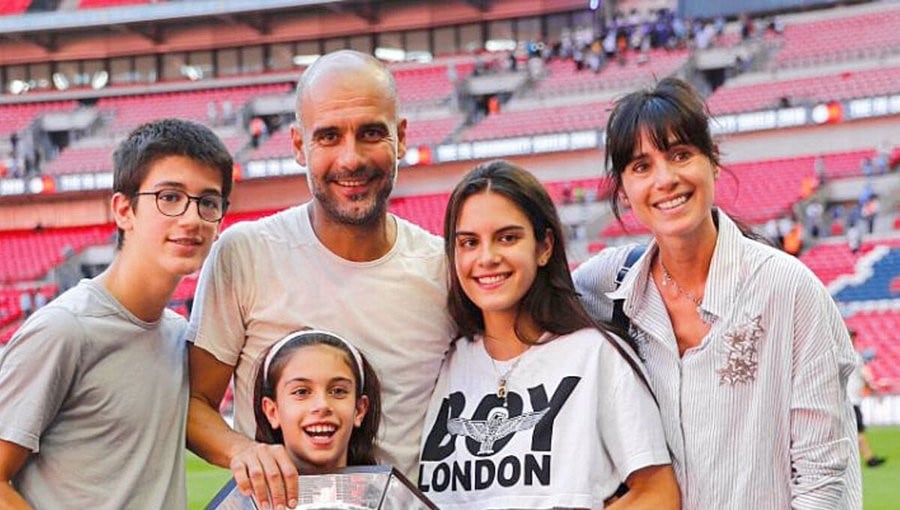 Imagen del entrenador Josep Guardiola acompañado de su esposa Cristina Serra y sus hijos en un estadio de fútbol.