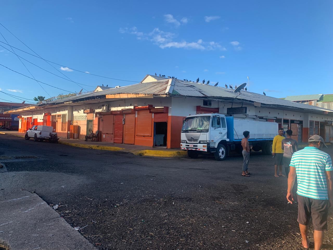 Fachada externa del Mercado Municipal de Puntarenas, algunos trabajadores están afuera.