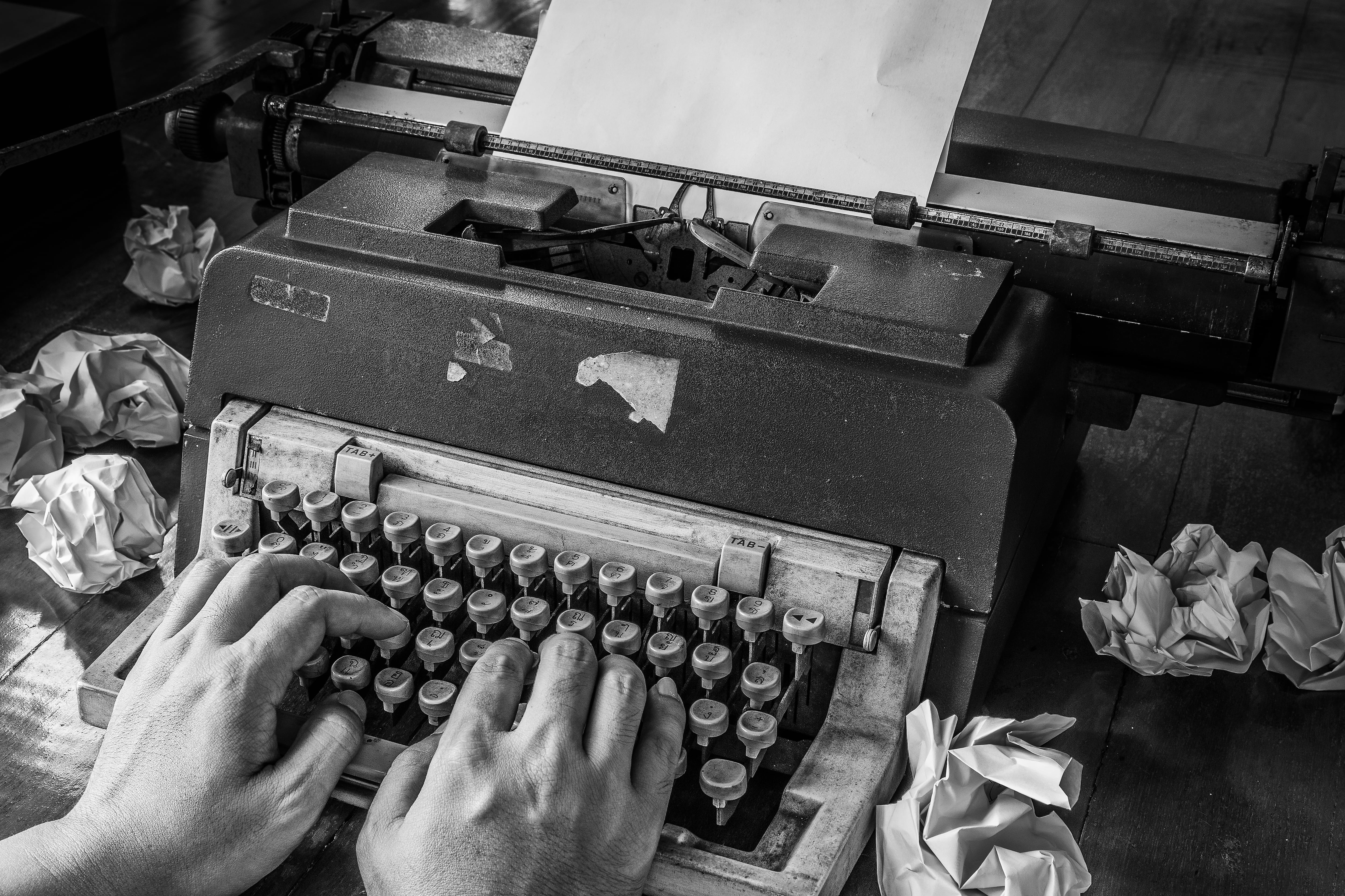 Máquina de escribir antigua y muchos papeles con pruebas descartadas