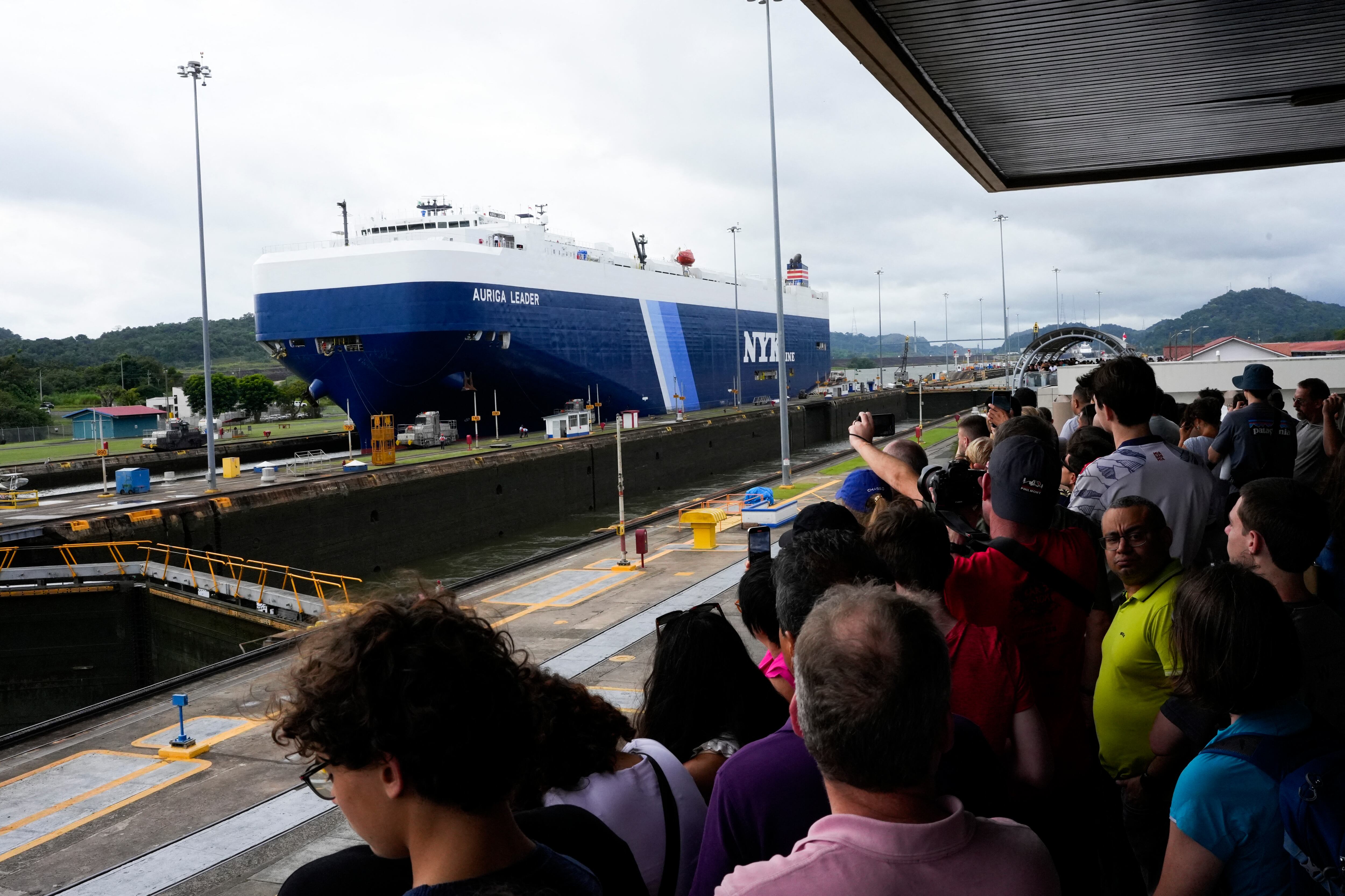 Turistas observan buques de carga pasar por el canal de Panamá
