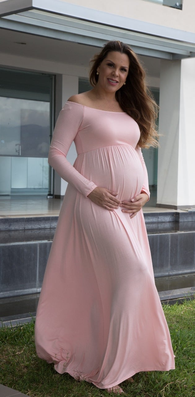 Una mujer embarazada con un vestido rosado.