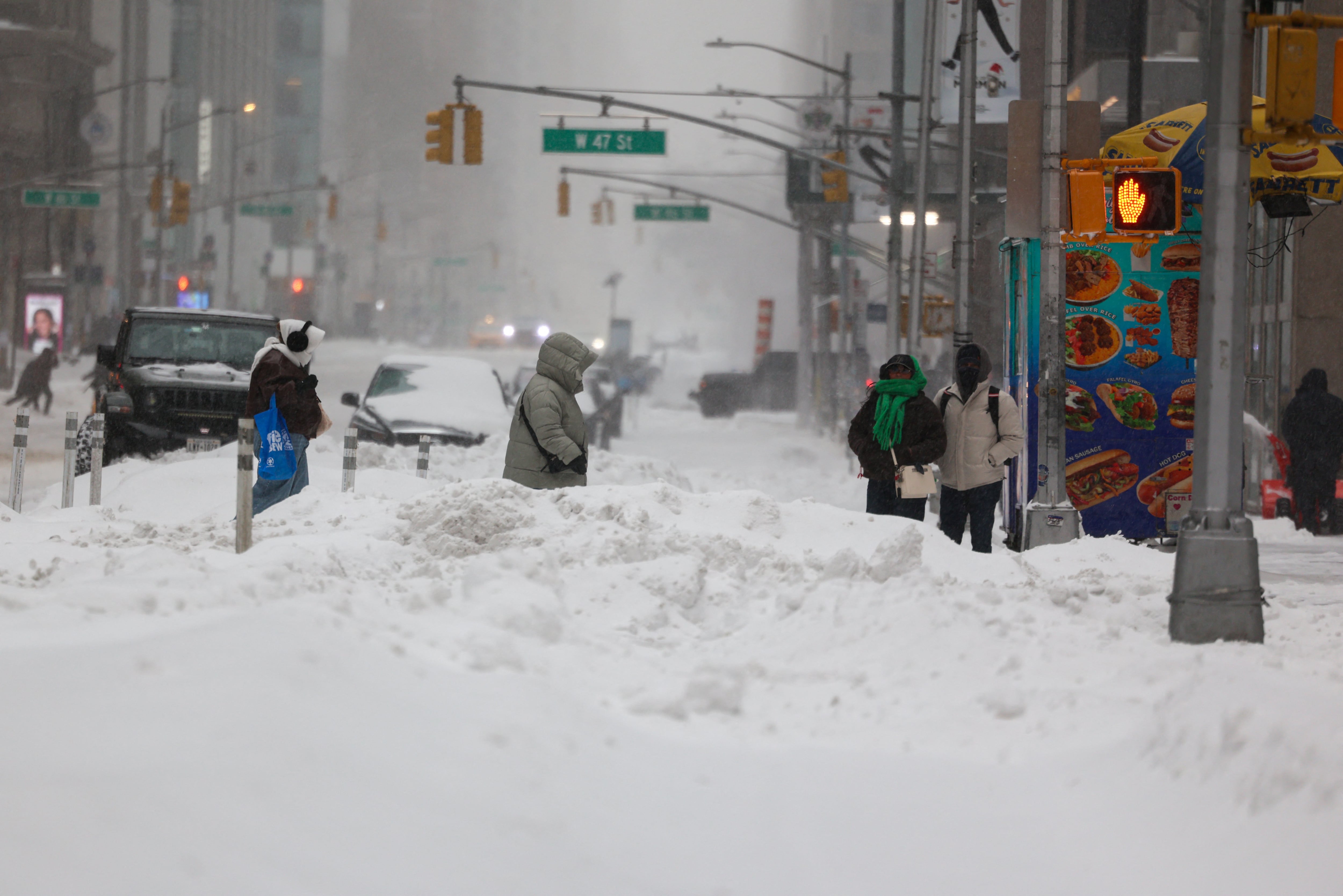Personas sobre la Sexta Avenida bajo la nieve en Nueva York este 25 de enero. Apagones, caos en el transporte y un frío glacial azotaron las zonas suroeste y central del país desde el sábado. Fotografía: