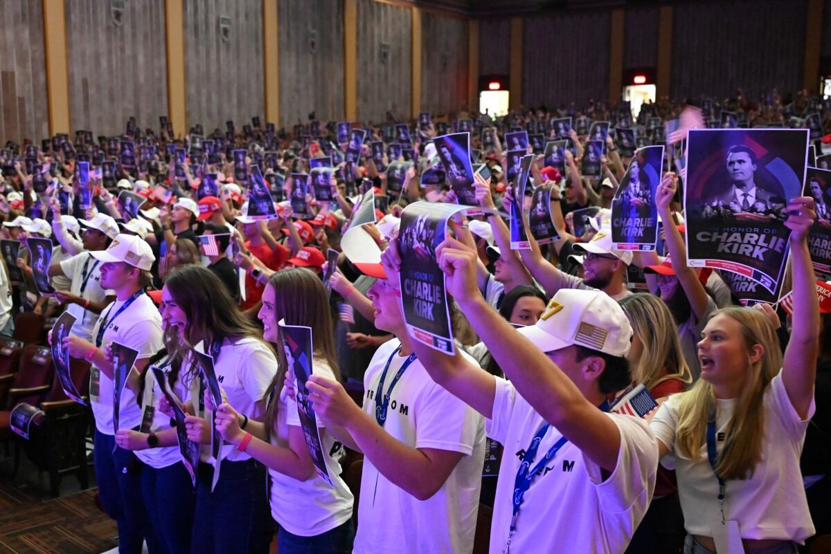 Attendees hold posters with a photo Charlie Kirk during an "American Comeback Tour" stop hosted by Turning Point USA in Burruss Hall at Virgina Tech university in Blacksburg, Virginia, on September 24, 2025.