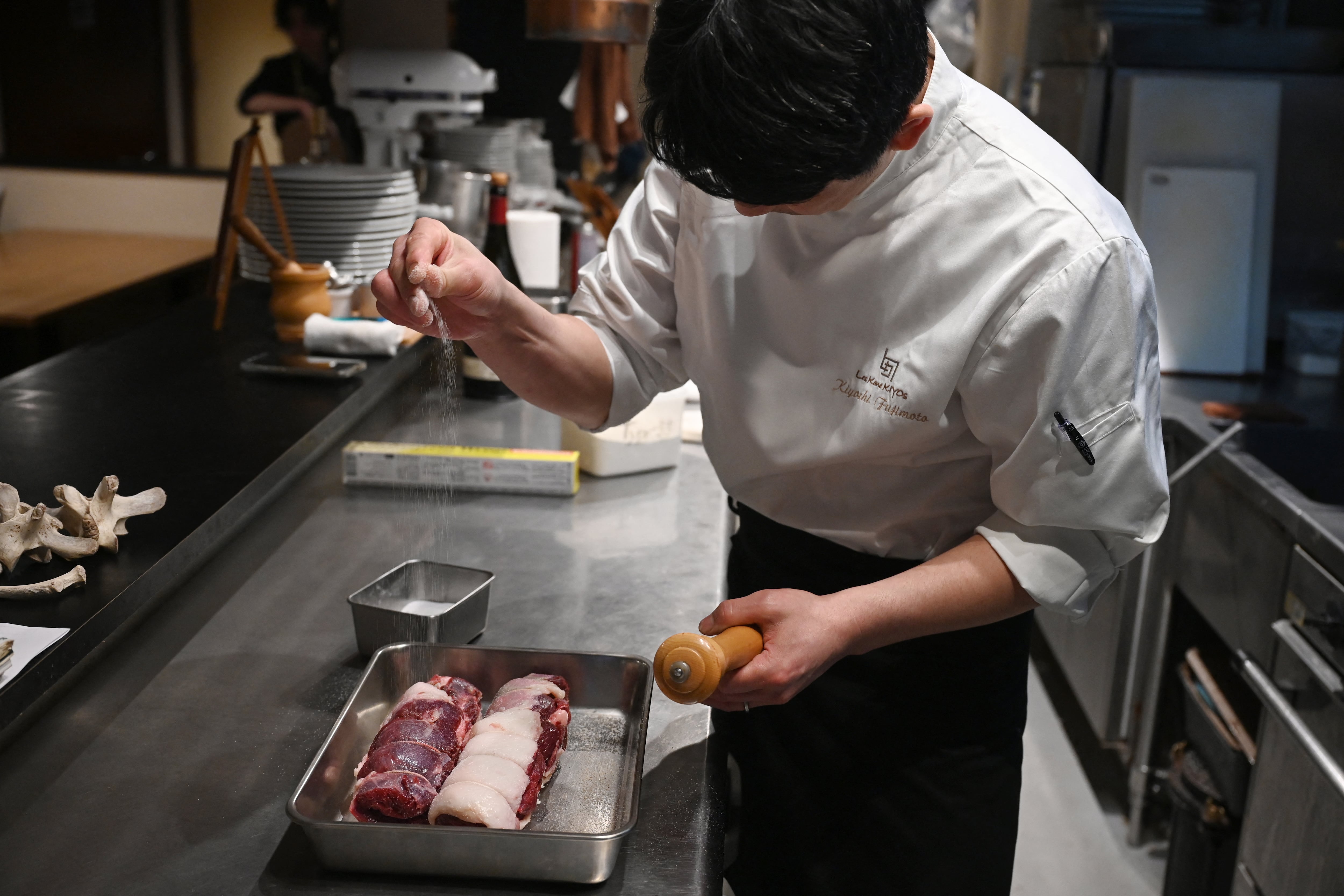 Chef Kiyoshi Fujimoto sazonando carne de oso en su restaurante de Sapporo, en la prefectura de Hokkaido, al norte de Japón.