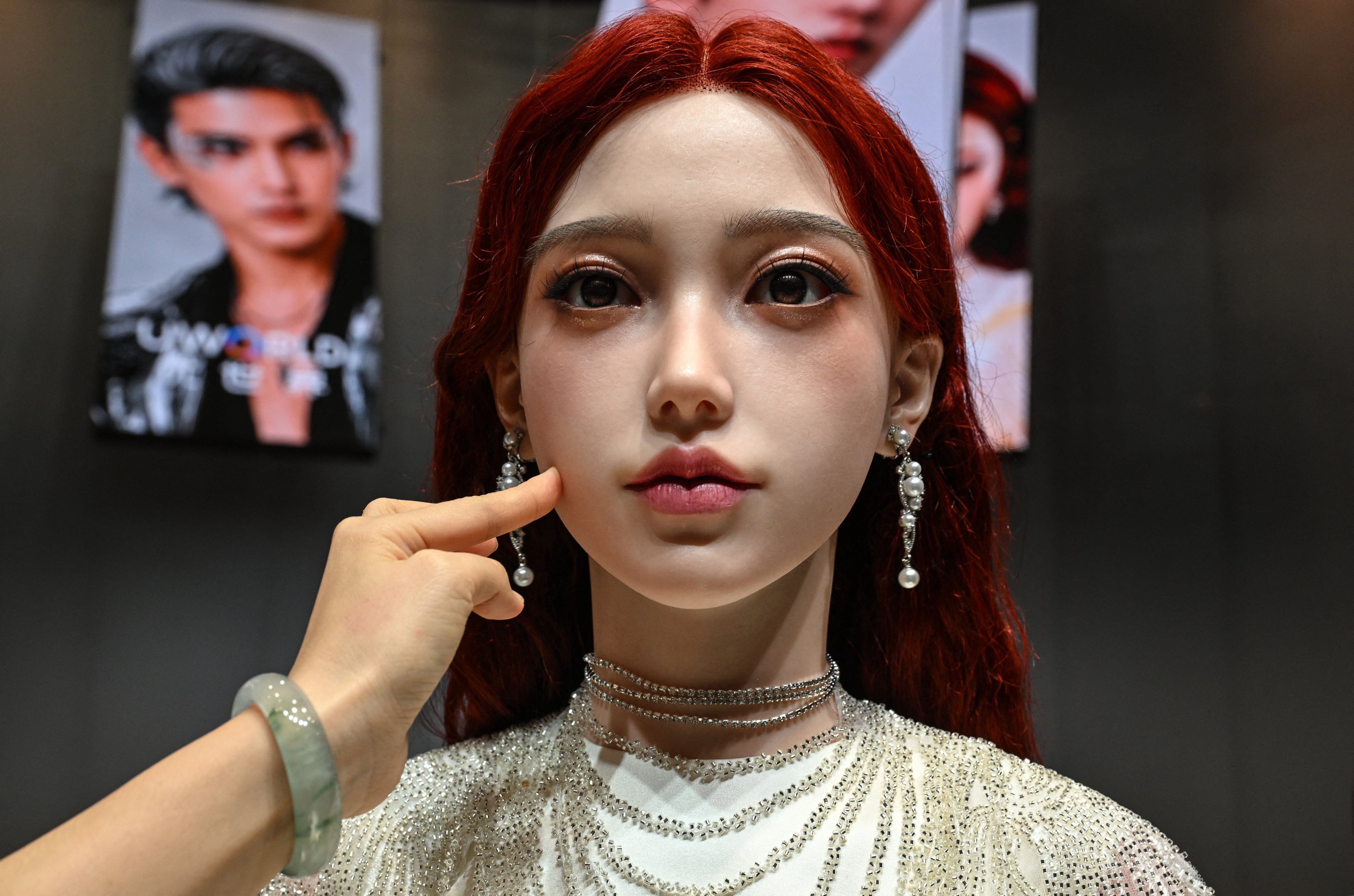 Una mujer toca el rostro de un robot humanoide durante la presentación del U1, producido por UWORLD, una marca de UBTECH Robotics, en Shenzhen, provincia de Guangdong, China, el 30 de junio del 2026. Con piel de silicona y una voz suave, la empresa china UBTech presentó androides de apariencia hiperrealista equipados con inteligencia artificial, concebidos como una alternativa para combatir la soledad. (Foto: ADEK BERRY / AFP)