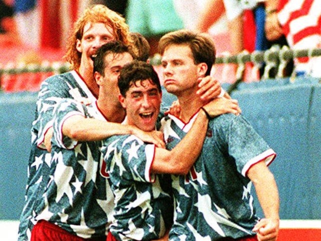 Eric Wynalda, de Estados Unidos (derecha), es abrazado por sus compañeros de equipo Alexi Lalas, John Harkes y Tab Ramos, de izquierda a derecha, tras marcar su gol en el primer tiempo el 18 de junio de 1994, durante el partido de la Copa del Mundo ante Suiza en el Pontiac Silverdome. Estados Unidos y Suiza empataron 1-1. (Foto: CHRIS WILKINS / AFP)