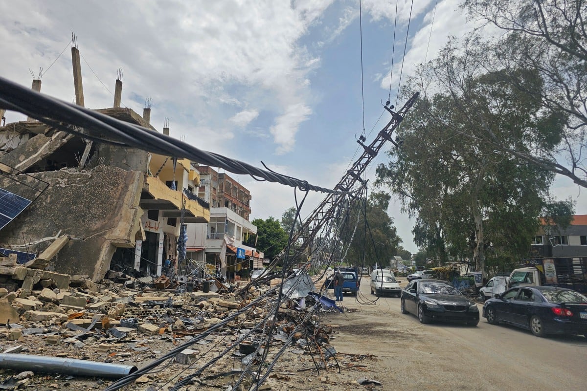 Residentes desplazados pasan junto a edificios dañados mientras regresan a sus hogares en la ciudad sureña libanesa de Nabatieh el 17 de abril de 2026.
