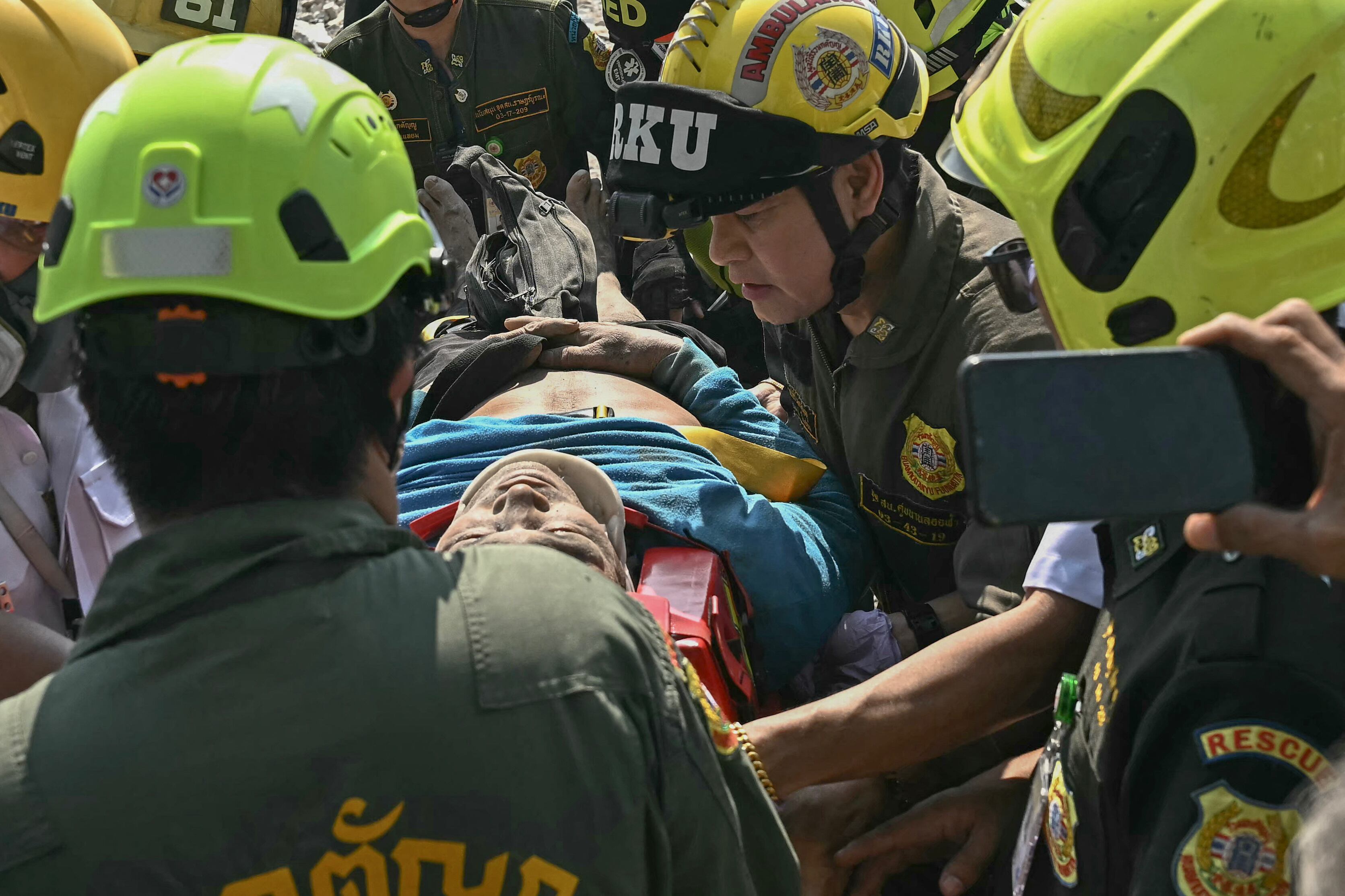 An injured man is rescued at a construction site where a building collapsed in Bangkok on March 28, 2025, after an earthquake. A powerful earthquake rocked central Myanmar on March 28, buckling roads in capital Naypyidaw, damaging buildings and forcing people to flee into the streets in neighbouring Thailand. (Photo by Lillian SUWANRUMPHA / AFP)