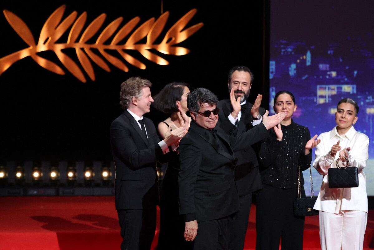 El director, guionista y productor iraní Jafar Panahi (al frente) y su equipo celebran en el escenario tras ganar la Palma de Oro por la película "Un simple accidente" durante la ceremonia de clausura de la 78.ª edición del Festival de Cine de Cannes