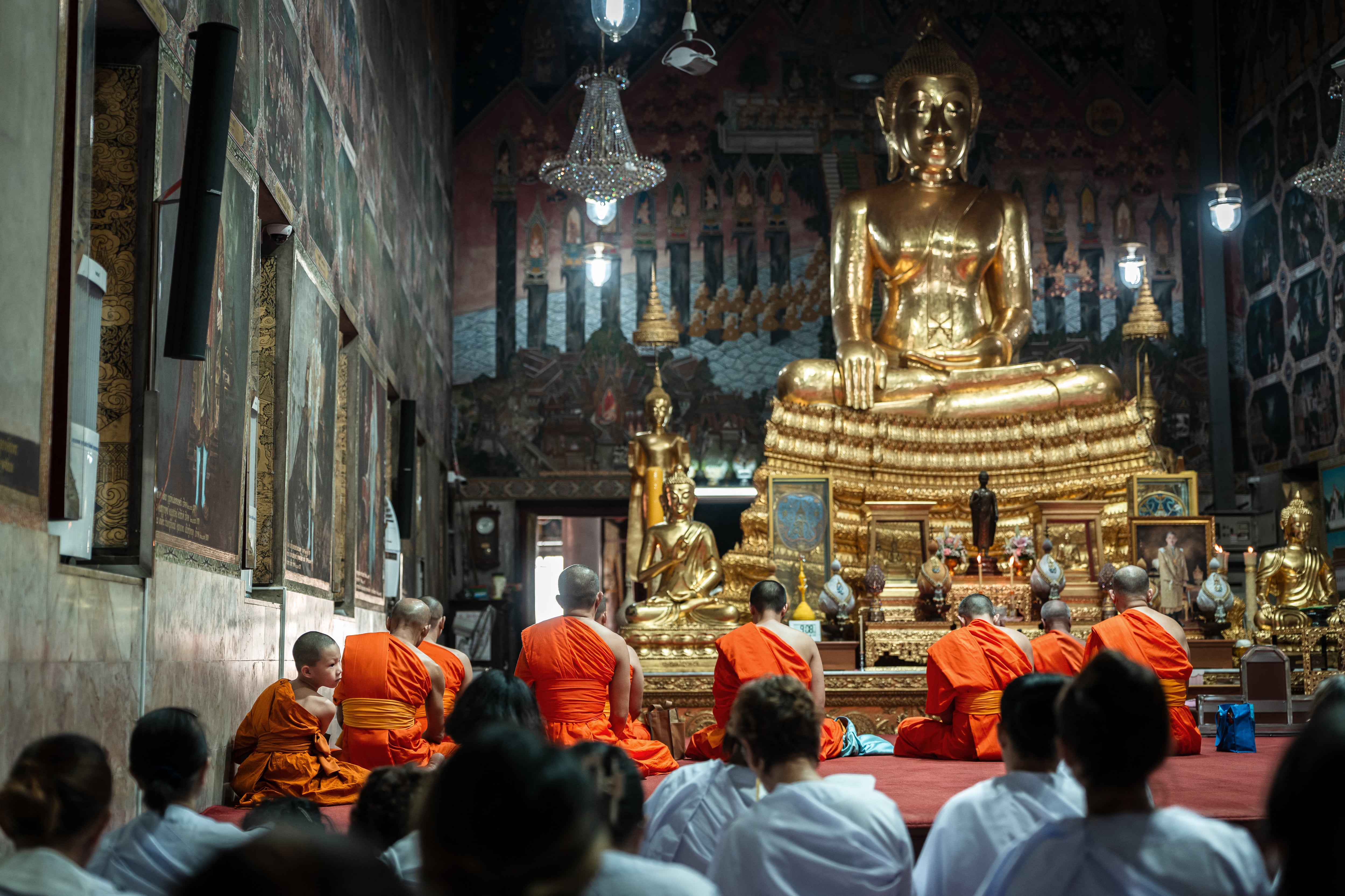 Monjes budistas tailandeses y devotos frente a una estatua de Buda en el templo Wat Pak Nam en Bangkok el 18 de julio. Fotografía: