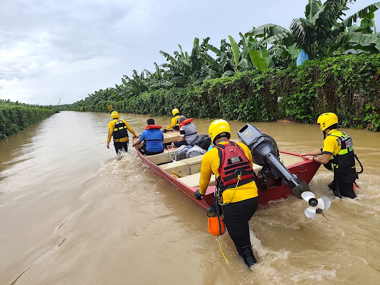 Bomberos trasladó a vecinos por un canal anegado en Matina durante las labores de evacuación y atención de las comunidades afectadas por las inundaciones este domingo.