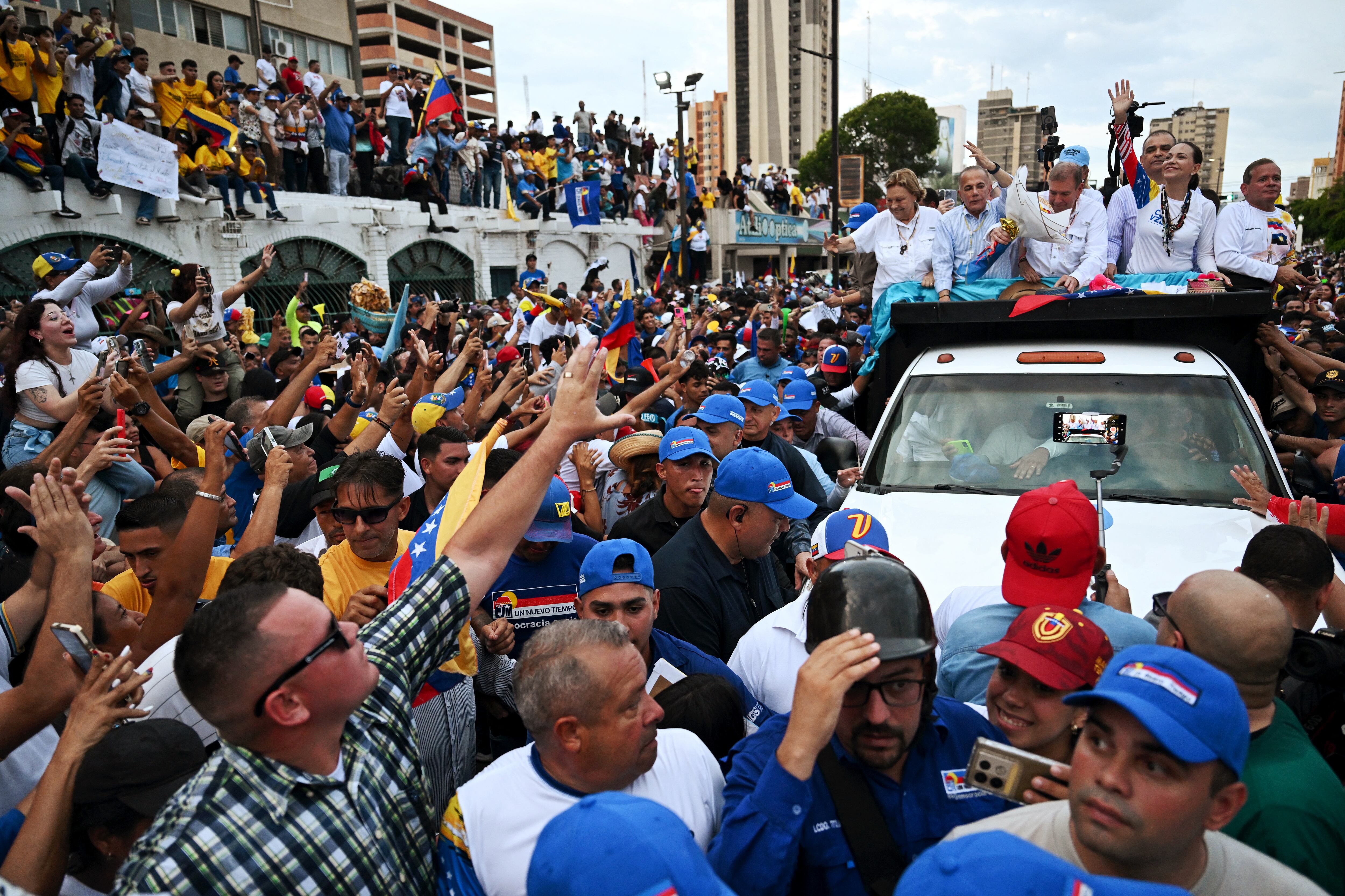 El candidato presidencial de la oposición venezolana Edmundo González Urrutia y la líder de la oposición María Corina Machado saludan a sus partidarios.