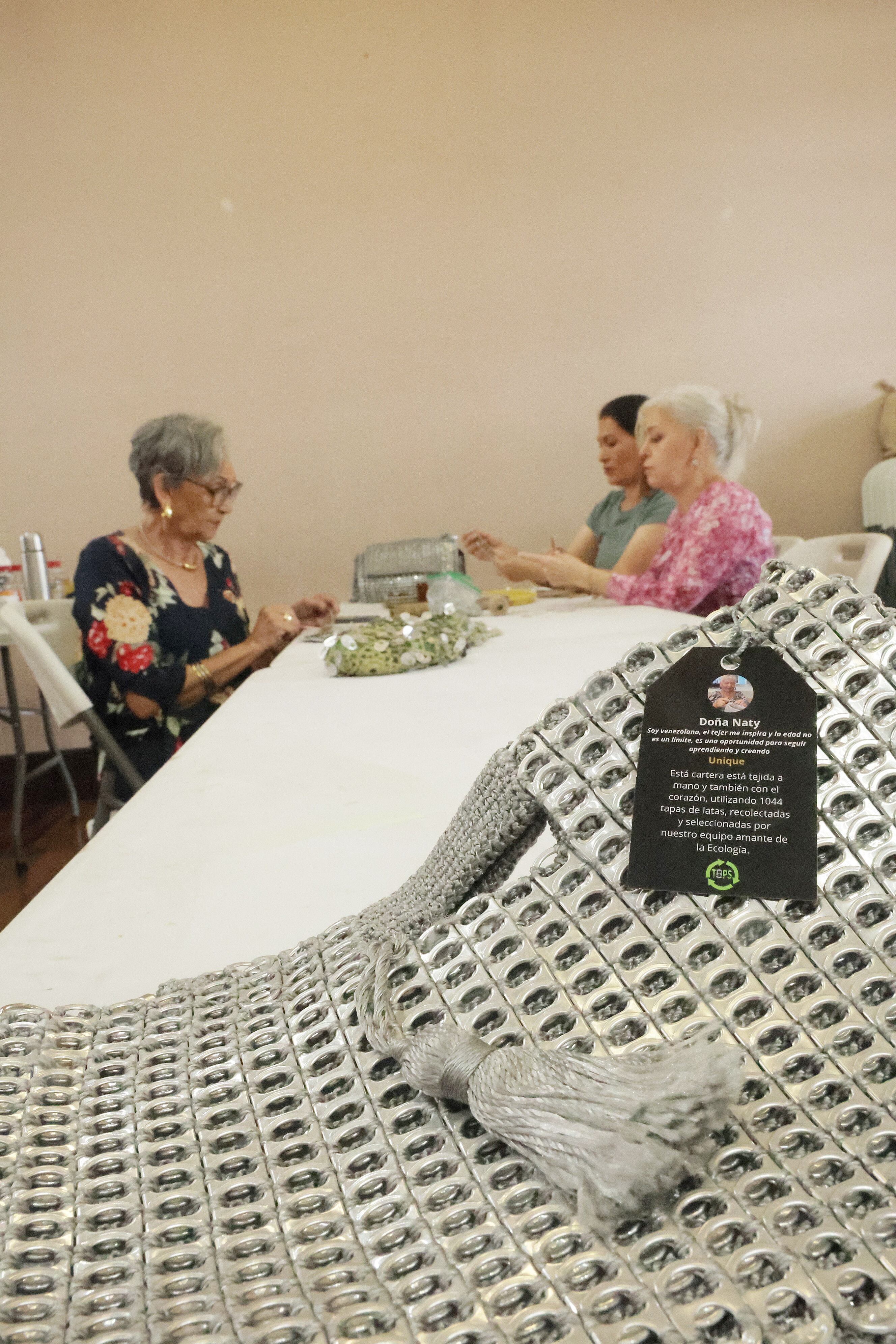 Lenis García enseña sus bolsos y da capacitación a alumnas quienes aprenden esta técnica