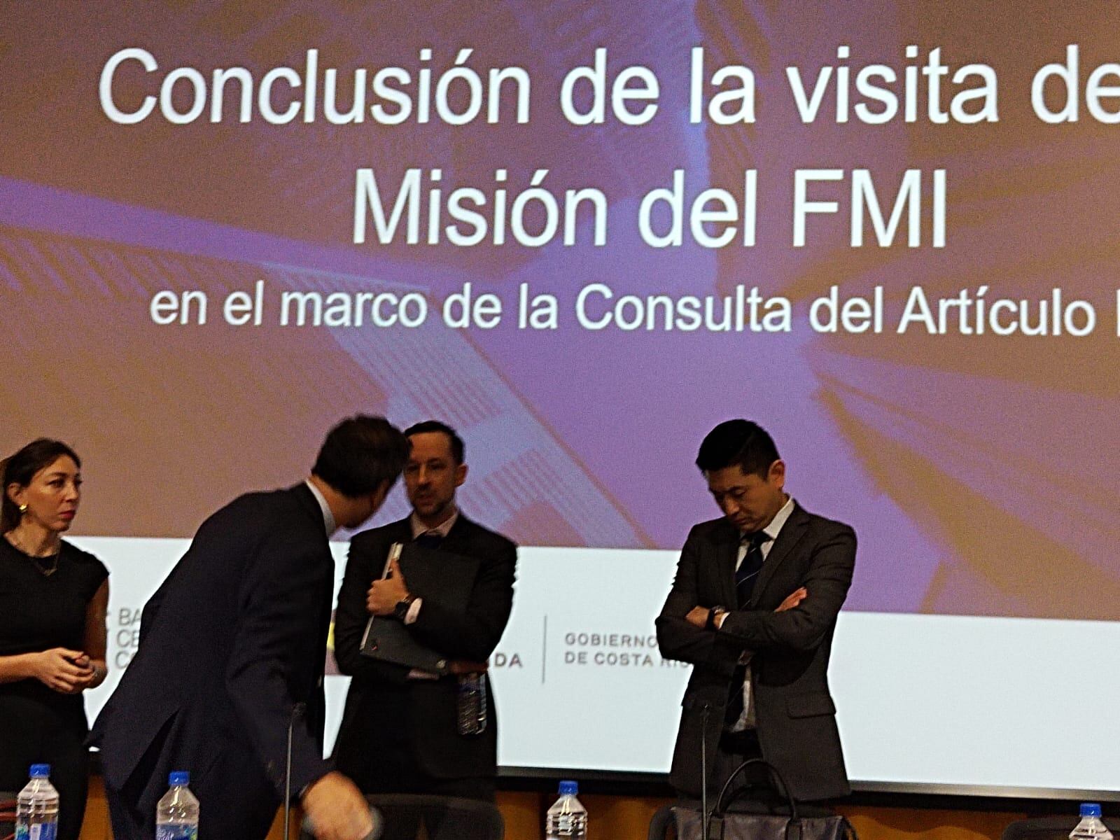 Funcionarios del Fondo Monetario Internacional (FMI) en una conferencia en San José, con un fondo que anuncia la conclusión de la visita de la misión del FMI.