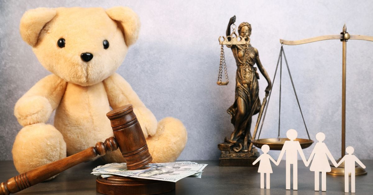 En la imagen un oso de peluche con un mazo de derecho, dinero y una estatua de la justicia.