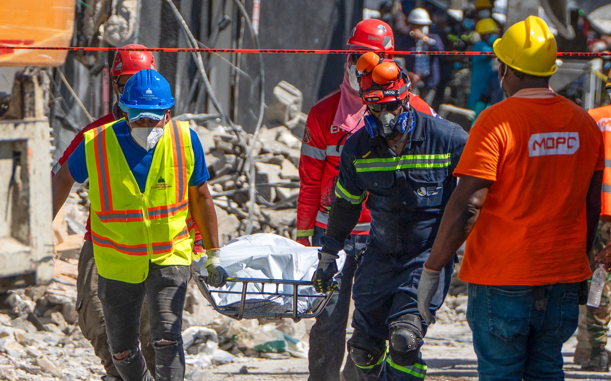 Rescue teams members carry the body of a victim from the Jet Set nightclub a day after the collapse of its roof in Santo Domingo on April 9, 2025. Rescuers raced to find survivors among the rubble of the nightclub where at least 124 people, including a former Major League Baseball star, were killed when the roof collapsed. (Photo by Francesco SPOTORNO / AFP)