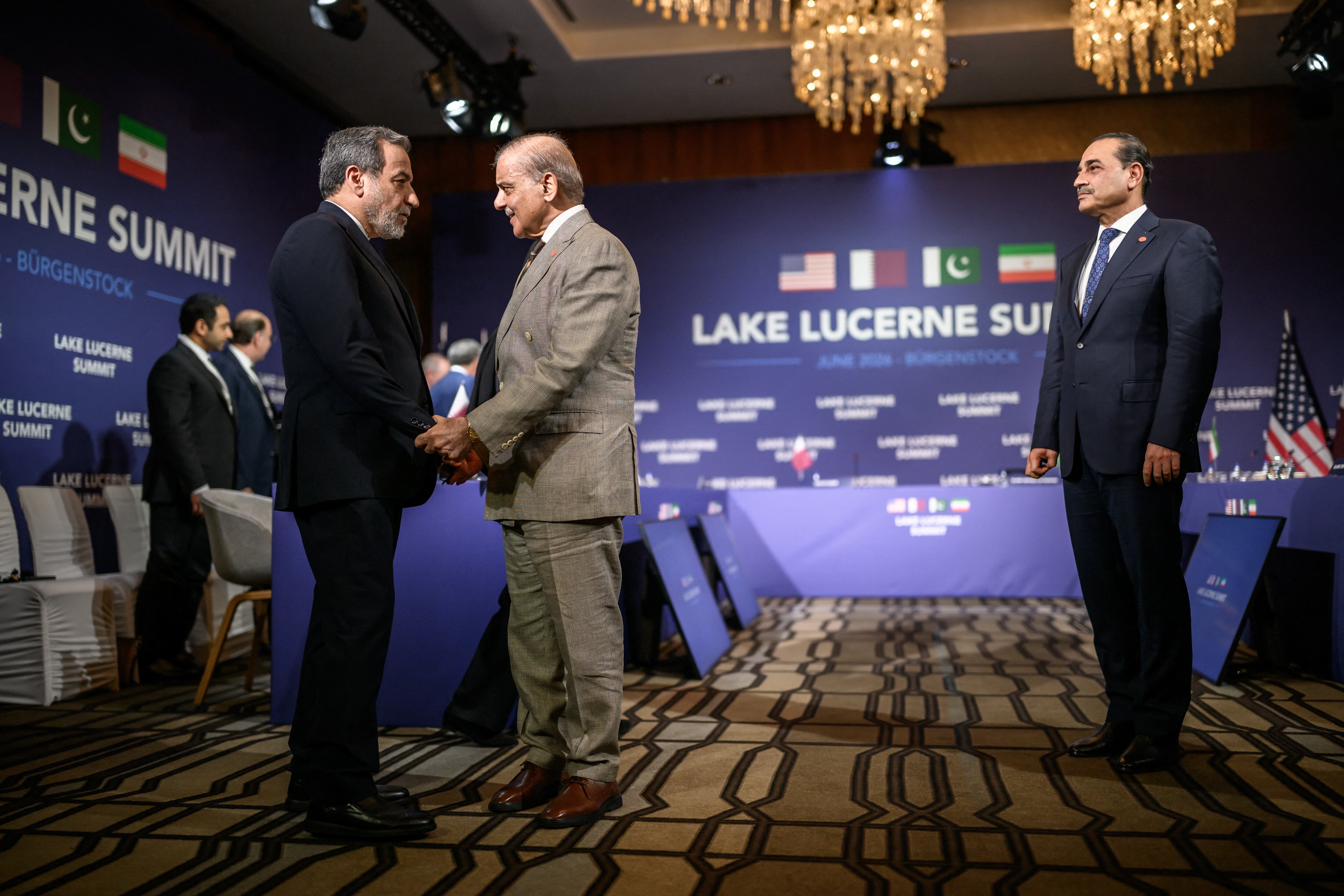 El ministro de Relaciones Exteriores de Irán, Abbas Araghchi (izq.), estrecha la mano del primer ministro de Pakistán, Muhammad Shehbaz Sharif (centro), junto al jefe del Estado Mayor del Ejército paquistaní, el mariscal de campo Asim Munir (der.), antes de una reunión cuatripartita entre Estados Unidos, Irán, Pakistán y Catar en el complejo hotelero de lujo de Bürgenstock, con vista al lago de Lucerna. El encuentro forma parte de conversaciones de alto nivel orientadas a avanzar en un acuerdo para poner fin al conflicto en Oriente Medio.