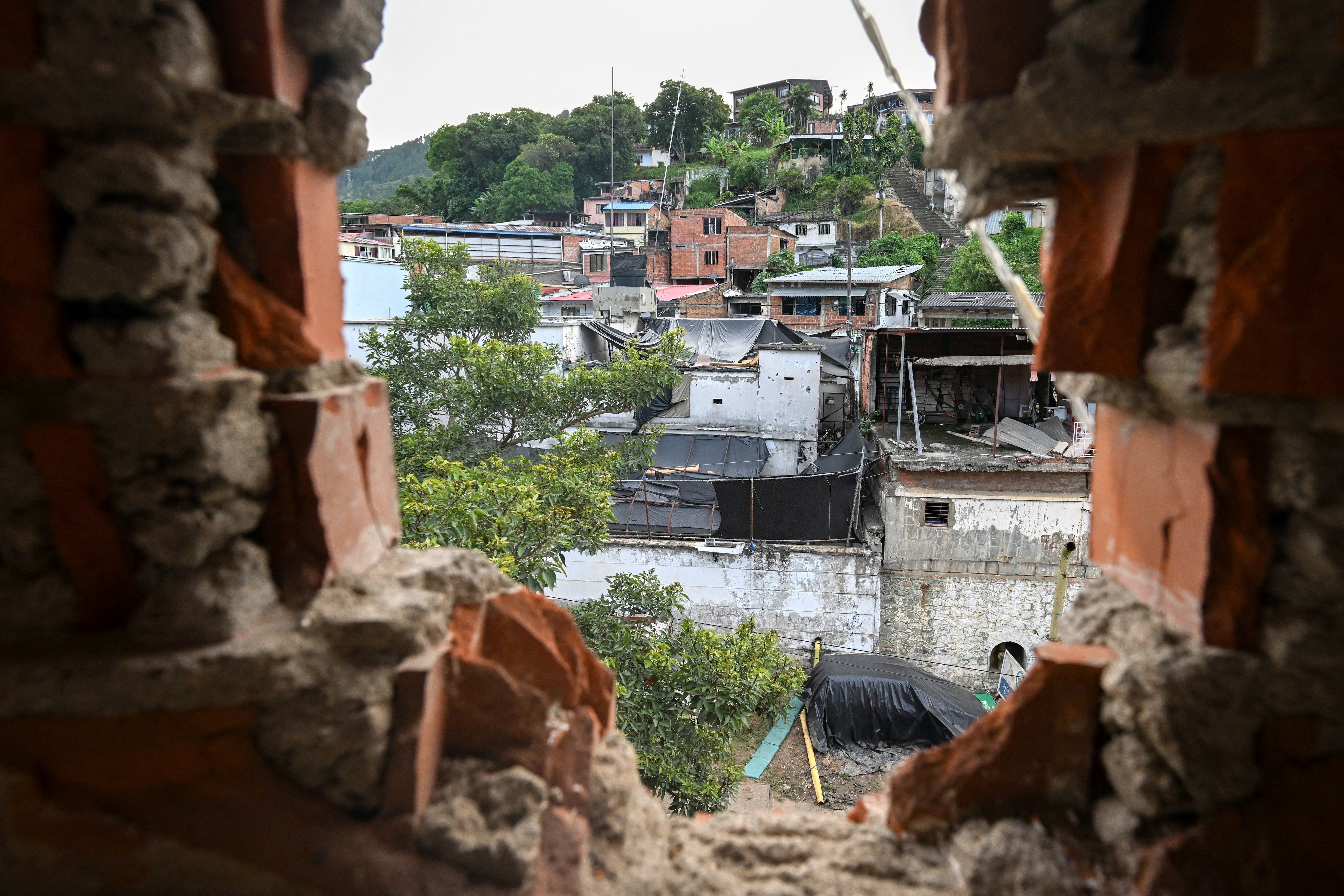 Una vista del vecindario a través del hueco de una pared destruida en un hotel de Suárez, en el departamento del Cauca, Colombia. Los lugareños elegirán este domingo 31 de mayo al sucesor del presidente Gustavo Petro, el primer mandatario de izquierda en la historia del país, quien impulsó sin éxito negociaciones de paz con distintos grupos armados.