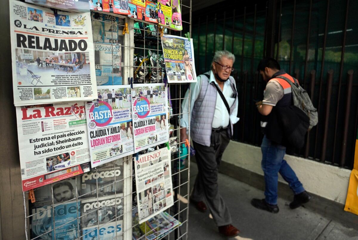 Personas pasan frente a un quiosco de periódicos al día siguiente de la elección de jueces en la Ciudad de México, el 2 de junio de 2025. La presidenta mexicana, Claudia Sheinbaum, respondió el lunes a las críticas sobre la elección de jueces sin precedentes en su país, después de que la mayoría de los votantes no votaran en una votación que sus oponentes calificaron de farsa.