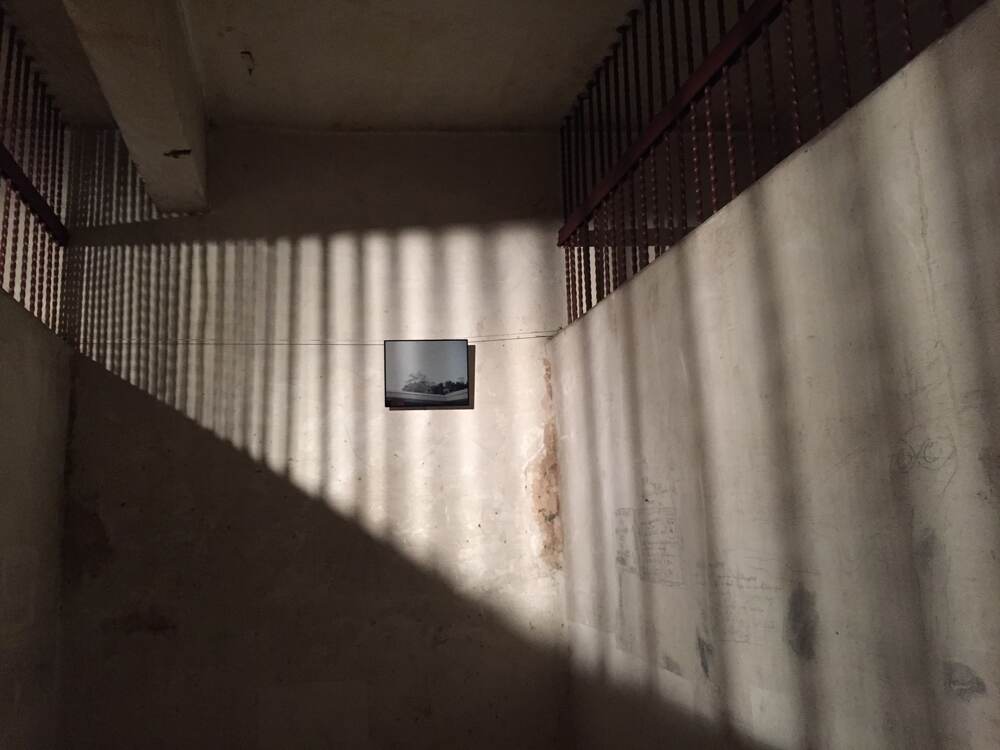 Dos ámbitos carcelarios. La pequeña imagen en el centro es de la serie Gráfica de encierro (2011-2016) y fue tomada por privados de libertad en un taller impartido por Hernández. Ahora, se exhibe en los antiguos calabozos del Cuartel Bellavista, actual sede principal del Museo Nacional.