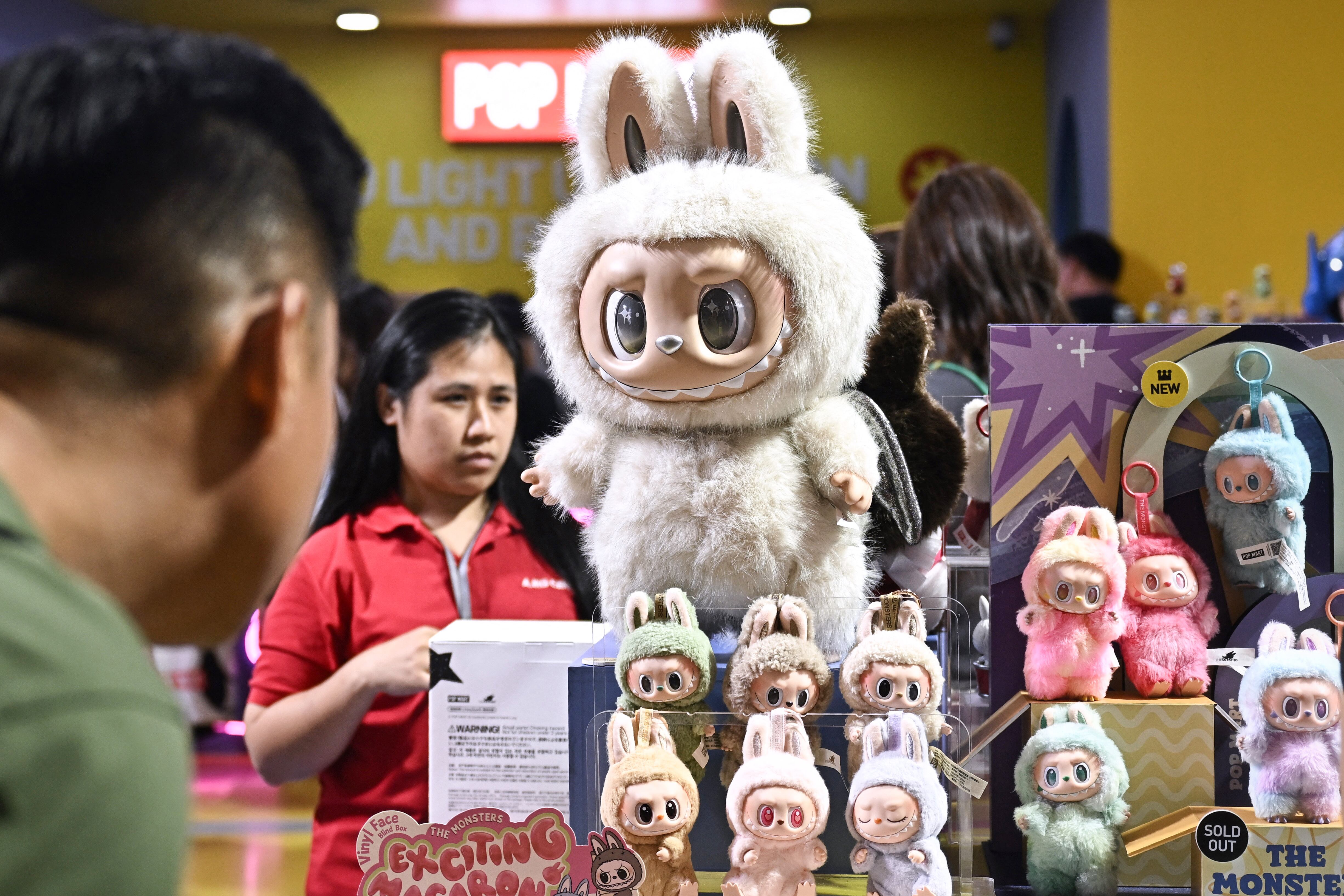 People look at collectable designer art toy Labubu at a Pop Mart pop-up store in Siam Center shopping mall in Bangkok on May 6, 2025. (Photo by Lillian SUWANRUMPHA / AFP)