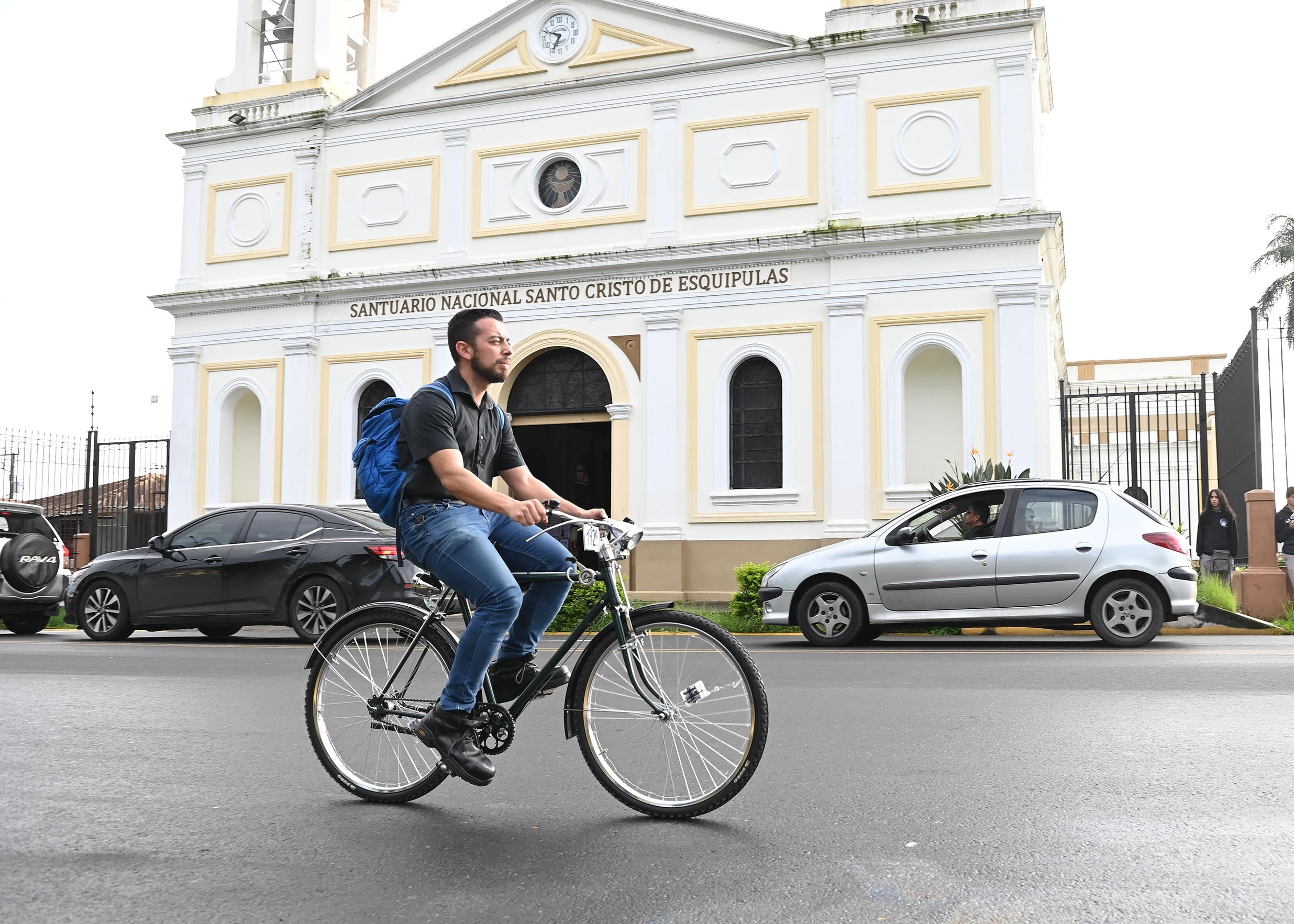 Un hombre en bicicleta pasa frente al Santuario Nacional Santo Cristo de Esquipulas en Alajuelita, cantón con la mayor ejecución presupuestaria en 2023.