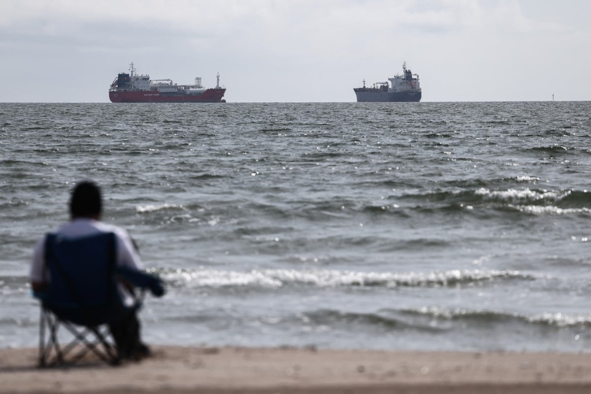 Un hombre ve pasar dos petroleros frente a las costas de Marsella, Francia.
