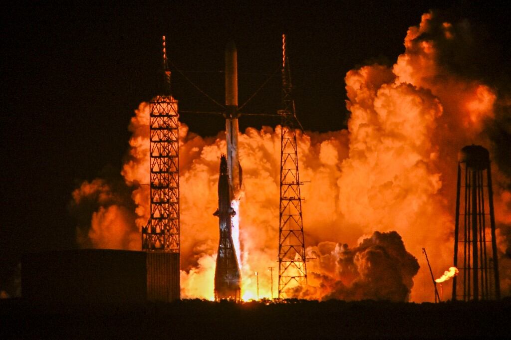Despegue nocturno del cohete New Glenn de Blue Origin, con llamas y humo rodeando la plataforma de lanzamiento en Cabo Cañaveral, Florida.