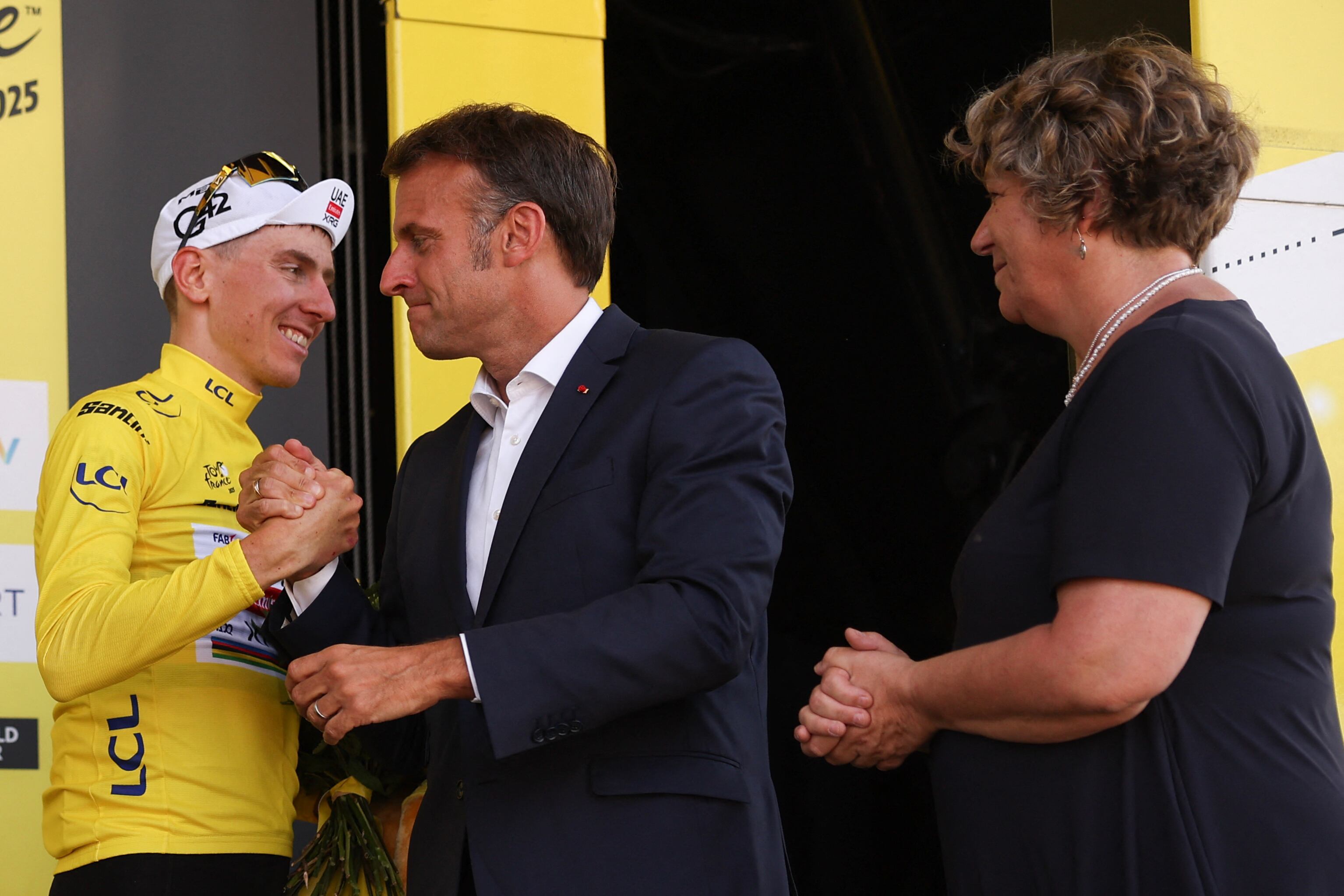 El presidente de Francia Emmanuel Macron congratula al corredor Tadej Pogacar luego de imponerle el jersey amarillo como líder del Tour de Francia.