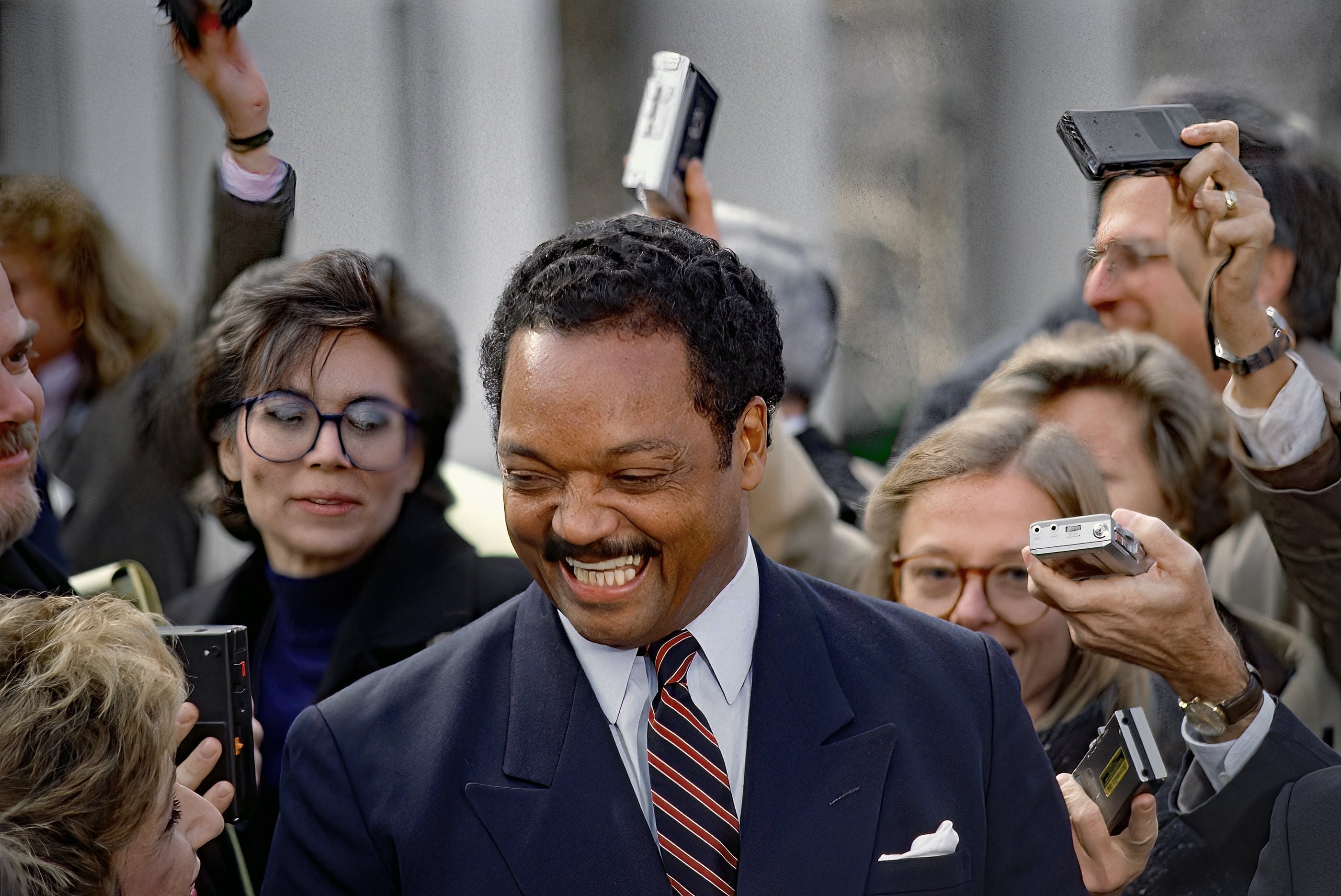30 de noviembre de 1988. El reverendo Jesse Jackson, entonces precandidato presidencial del Partido Demócrata, sonríe ante una pregunta de una reportera, en las afueras de la Casa Blanca.