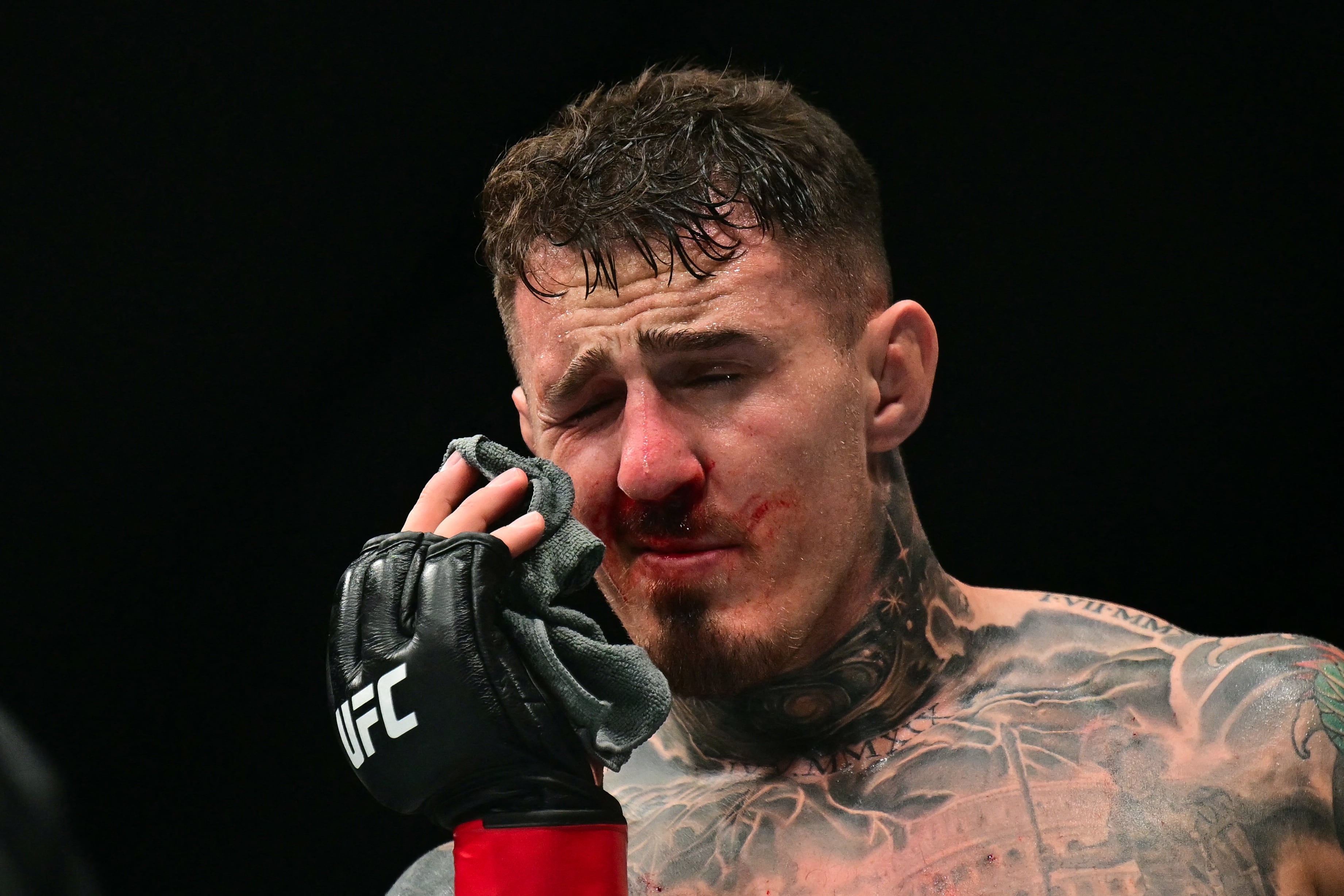 El británico Tom Aspinall reacciona tras recibir un golpe en el ojo mientras enfrentaba al francés Ciryl Gane durante su combate por el título de peso pesado del UFC 321, realizado en la Etihad Arena de Abu Dabi la madrugada del 26 de octubre de 2025. (Foto: Giuseppe Cacace / AFP)