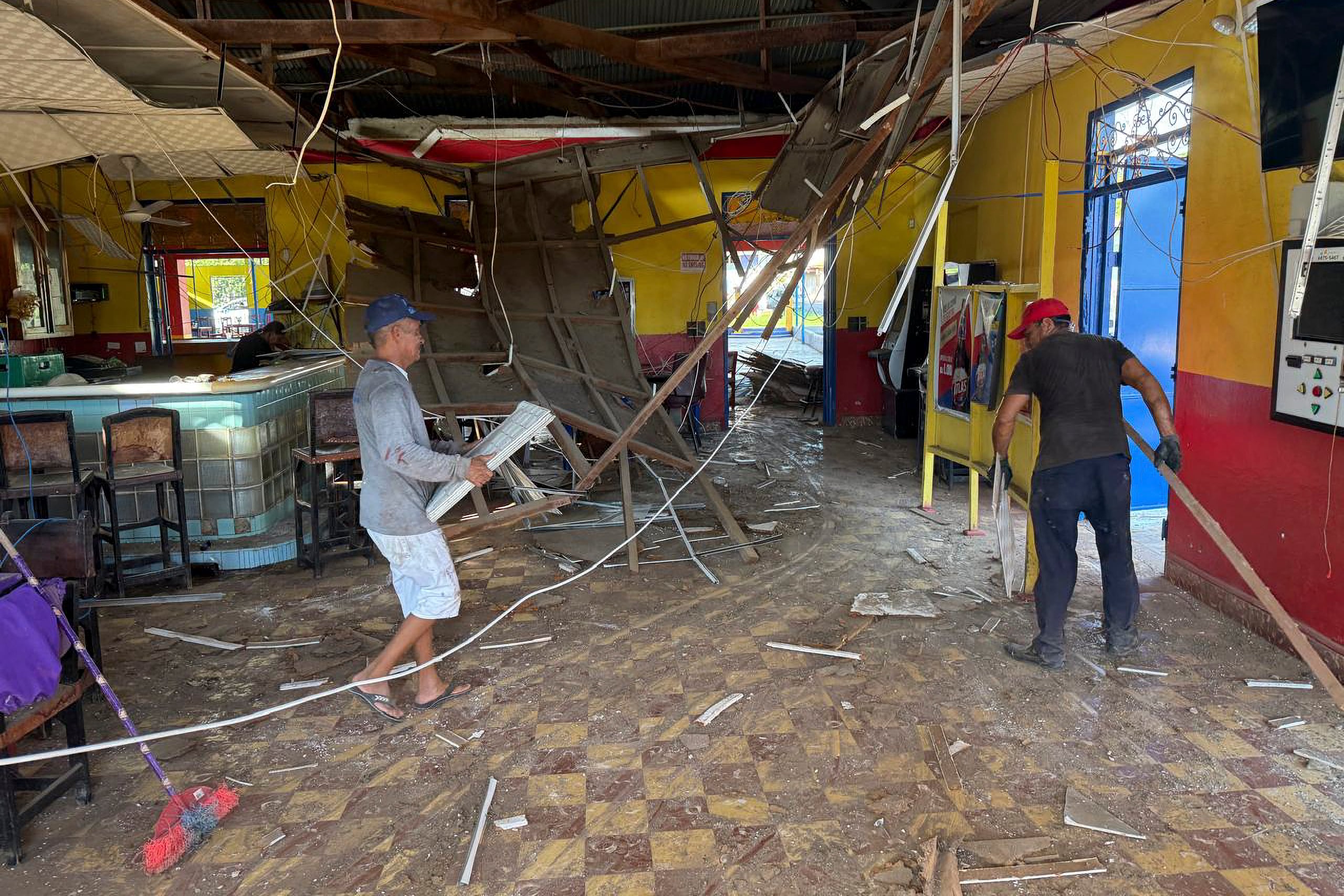 Varias personas retiran escombros del interior de un bar en Chitré, Panamá, este sábado 10 de octubre, un día después del terremoto de magnitud 7,7 que dejó al menos 27 heridos y daños en edificios y carreteras.