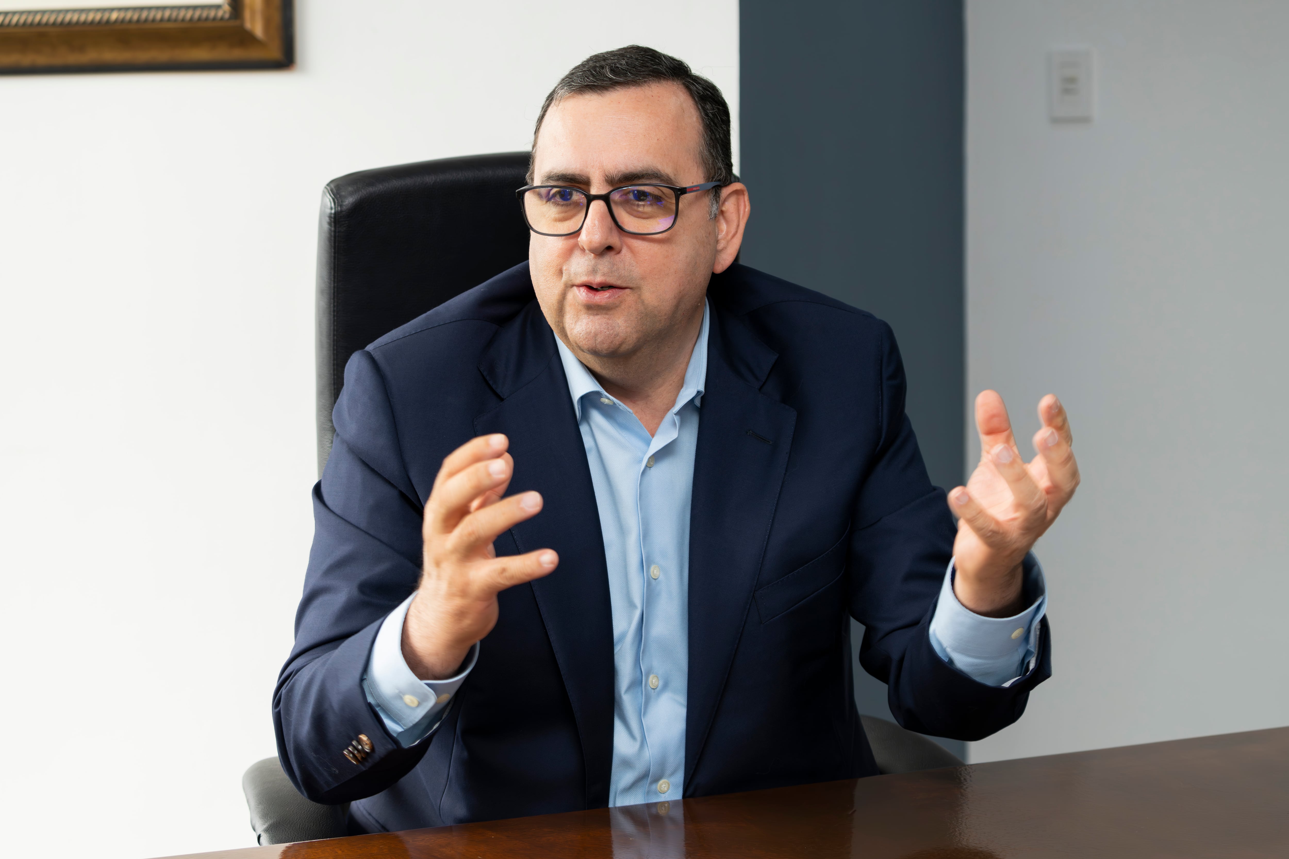 Arturo Giacomin, presidente ejecutivo de Banco Davivienda en Costa Rica, gesticula mientras habla durante una entrevista en la que aborda el desempeño financiero del banco en 2024 y los efectos de la fusión con Scotiabank en el sector bancario costarricense.