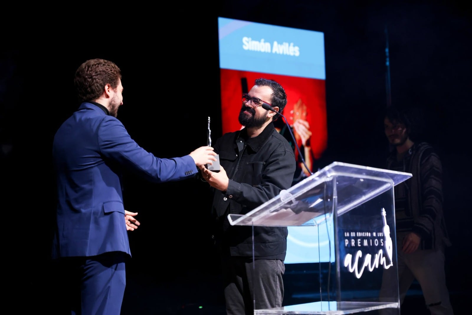 El músico costarricense Sebas Guillem hace entrega del Premio Artista Revelación de ACAM a Simón Avilés.