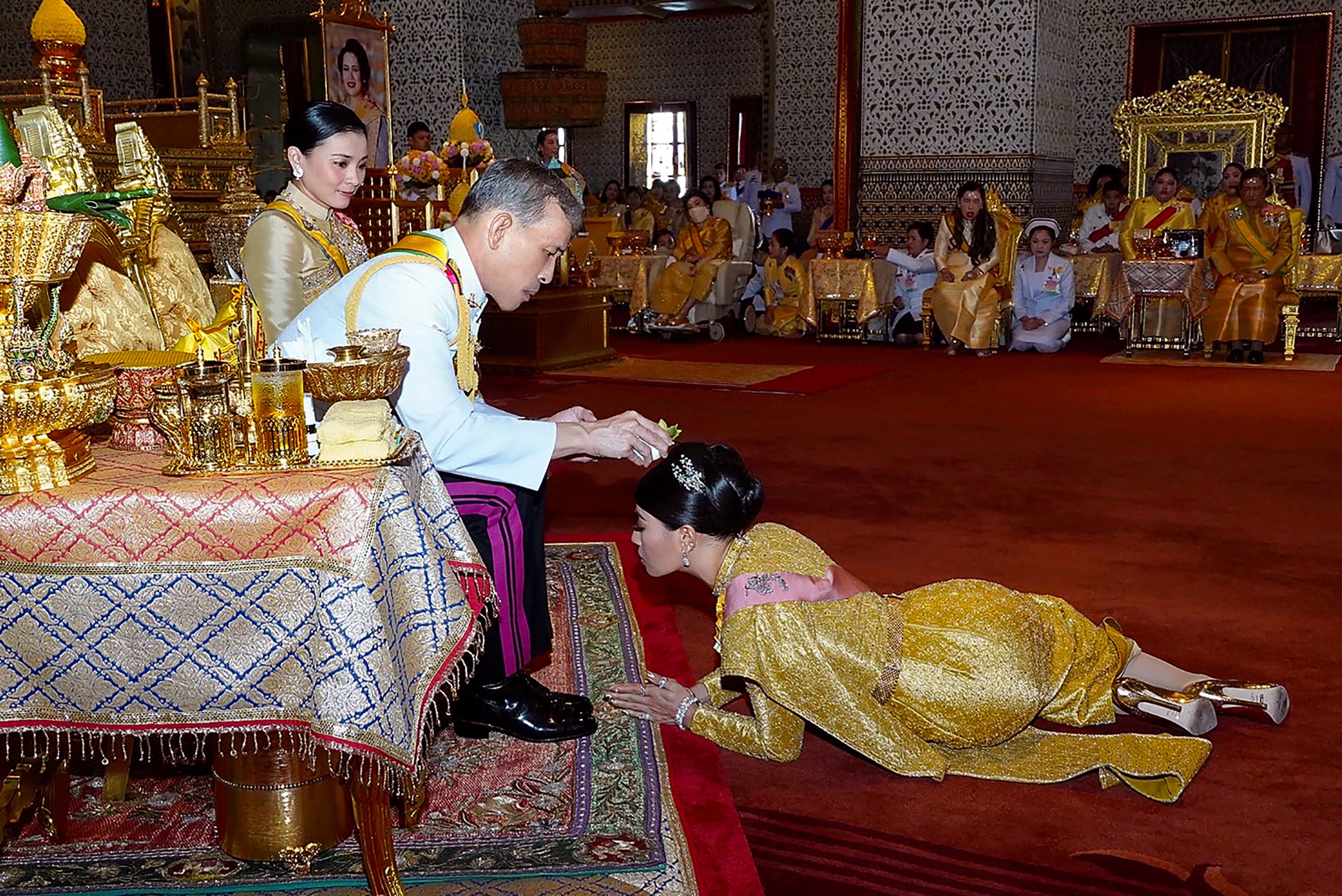 Esta imagen distribuida por la Oficina de la Casa Real de Tailandia, tomada y publicada el 5 de mayo del 2019, muestra al rey de Tailandia Maha Vajiralongkorn (C) ungiendo a su hija, la princesa Sirivannavari Nariratana (D), mientras la reina Suthida observa durante una ceremonia de coronación en el Gran Palacio de Bangkok.