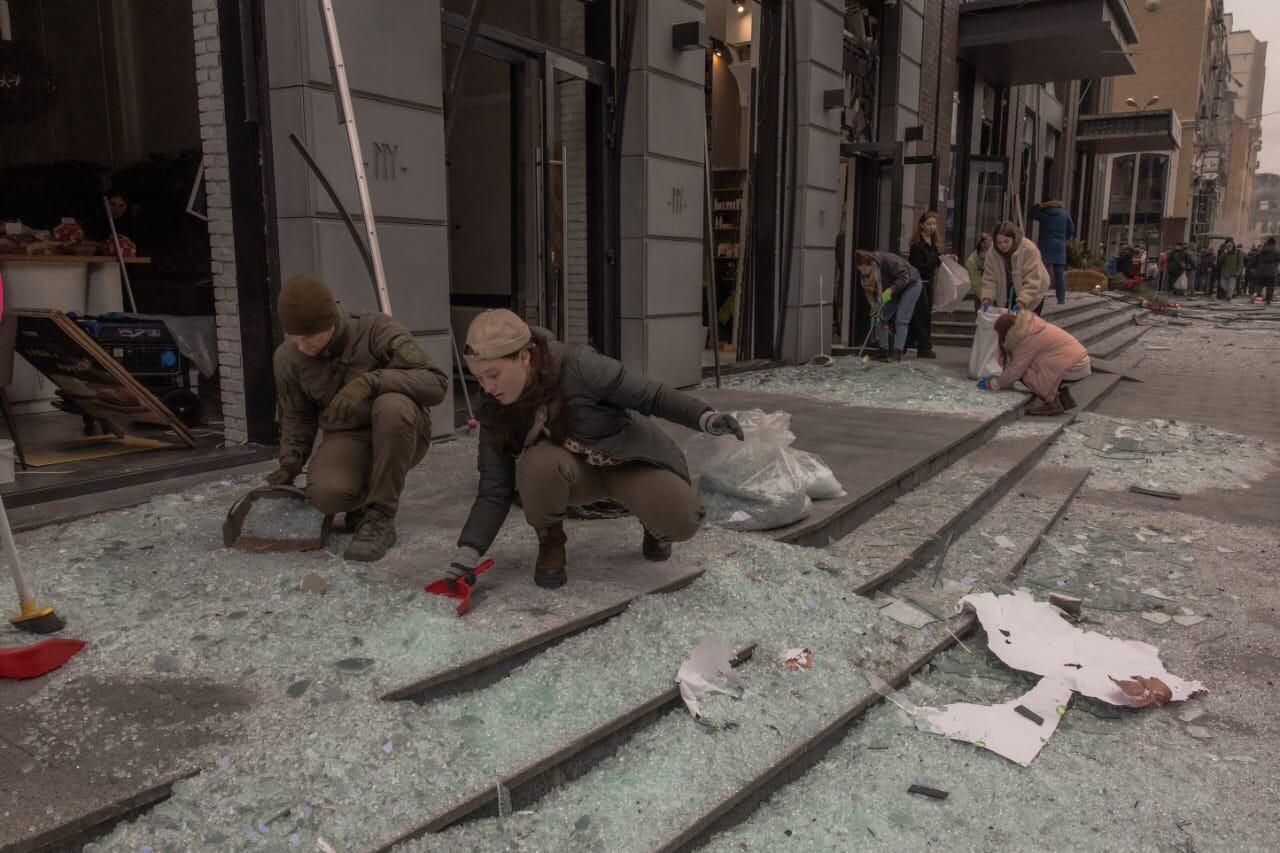 Personas limpian vidrios rotos en el lugar de un ataque con misiles en Kiev, el 20 de diciembre de 2024, en medio de la invasión rusa de Ucrania.