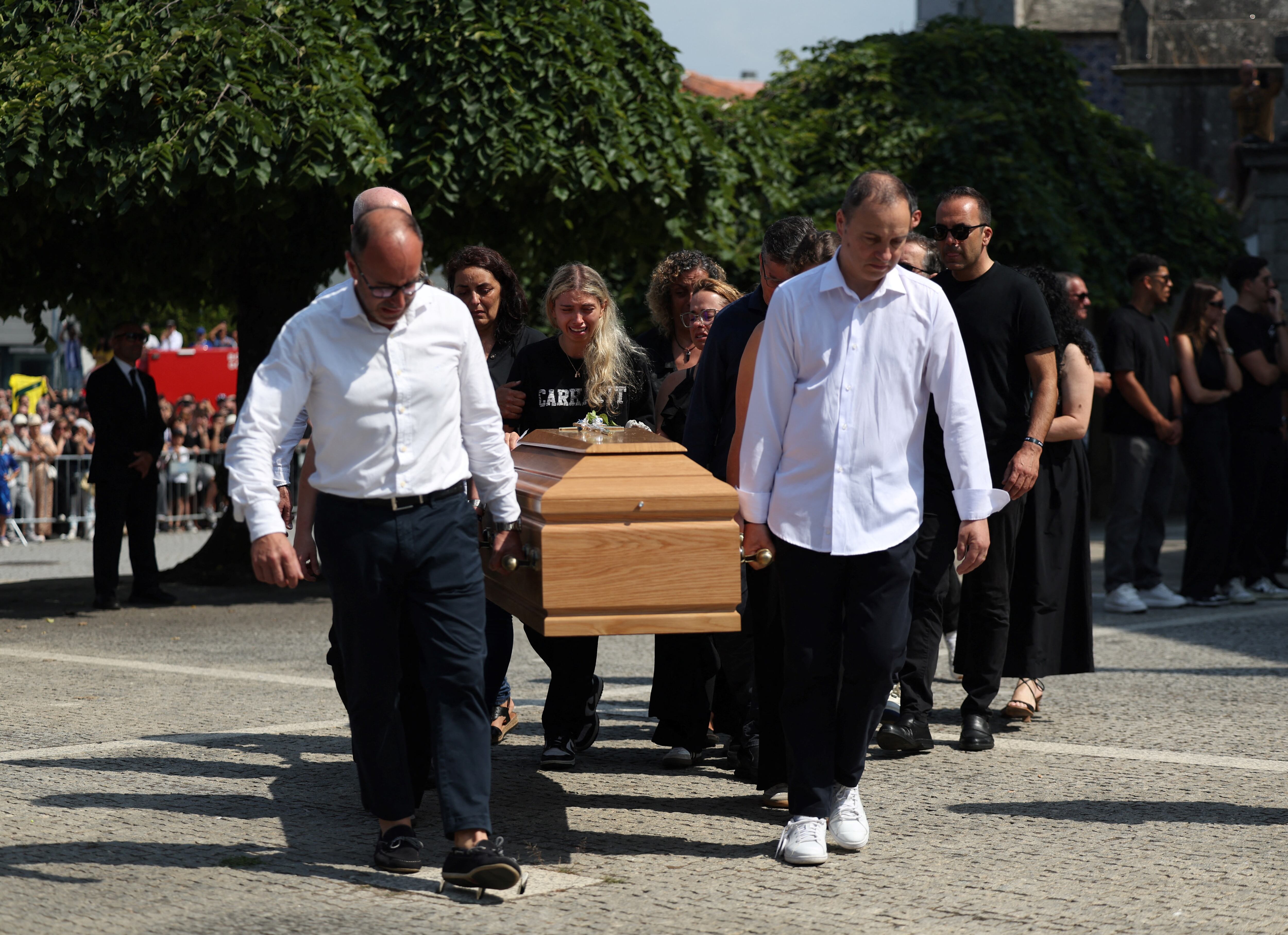 Familiares siguen el féretro del futbolista portugués André Silva al salir de la iglesia, tras la ceremonia fúnebre.