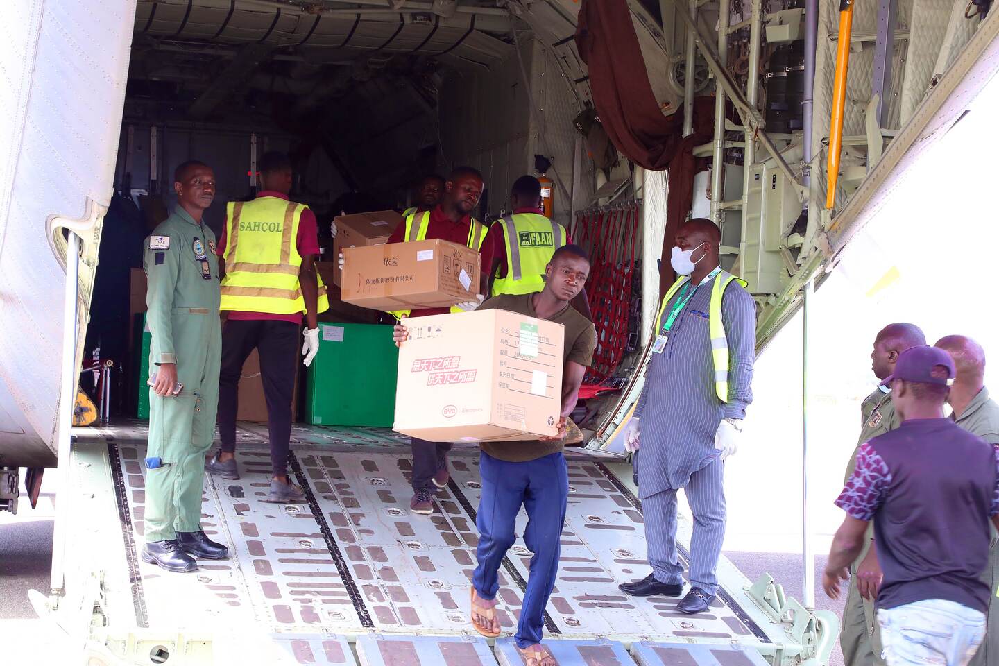 Workers unload a consignment of medical supplies donated by Chinese billionare, Jack Ma, to help deal with the COVID-19 coronavirus impact, after it arrived at the Nnamdi Azikiwe International Airport in Abuja, Nigeria, on March 25, 2020. - As the global pandemic takes root in Africa, Chinese billionaire Jack Ma announced he was donating 20,000 testing kits, 100,000 masks and 1,000 protective suits to each of the continent's 54 countries (Photo by Kola SULAIMON / AFP)