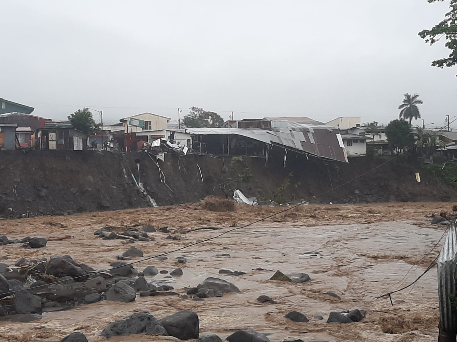El material arrastrado desde aguas arriba golpeó las laderas del río Turrialba que en algunas zonas se llevó postes, caminos y casas. Foto: CNE.