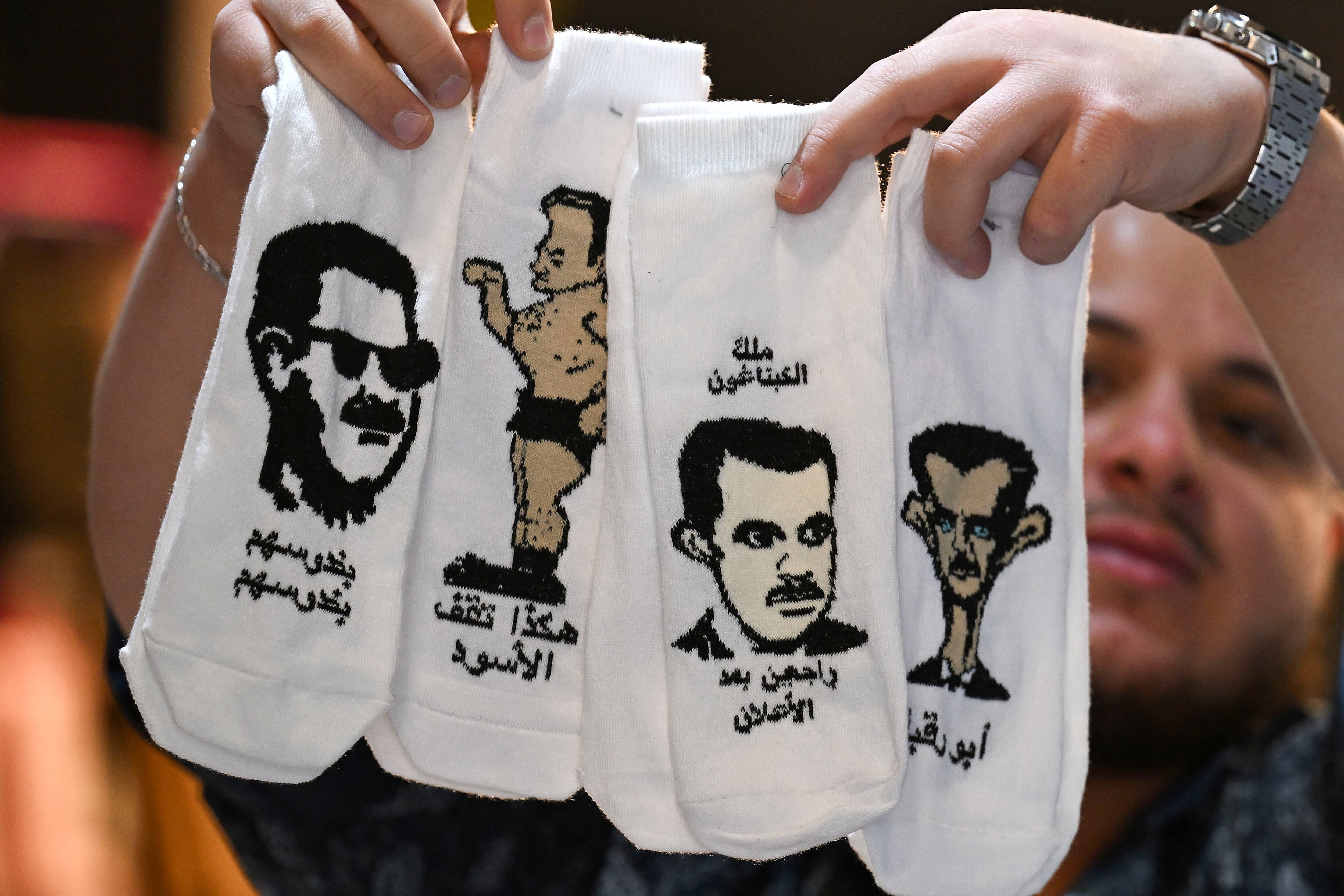 Un vendedor exhibe calcetines con caricaturas del derrocado líder sirio Bashar al-Assad en su tienda de Damasco este 4 de mayo. Fotografía:
