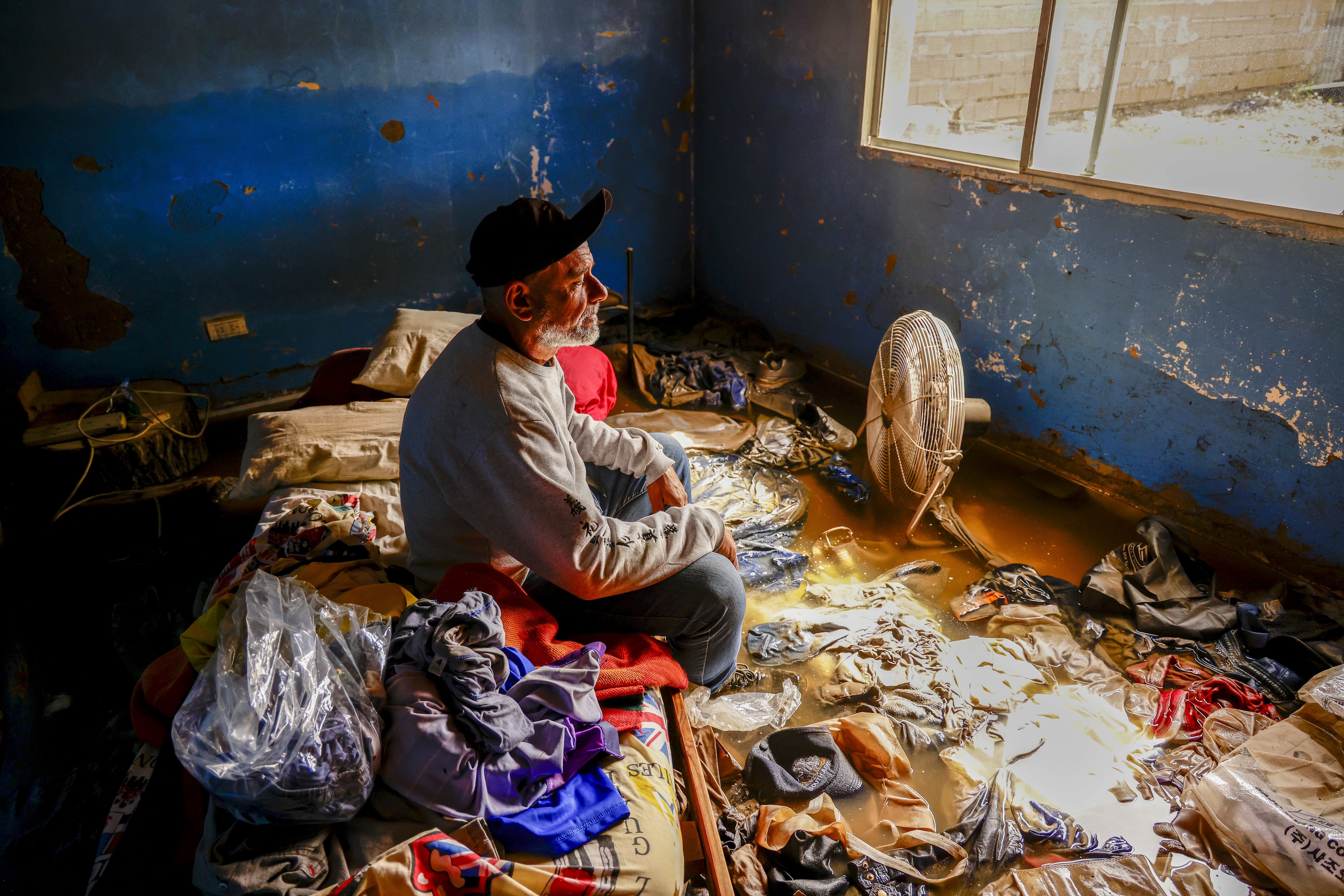 Inundación sin precedentes en Bahía Blanca, Argentina, marzo 2025. En Ingeniero White, el barrio fabril frente al puerto de Bahía Blanca, Gabriel Loffredo perdió todo. En su habitación mira toda su ropa flotando, desconsolado. Los restos de humedad, el barro y los muebles destrozados muestran el 1.40 m aproximado al que habría llegado, en algunas casas, el agua. Elegimos esta imagen porque sintetiza, con crudeza y al mismo tiempo con gran valor estético, el impacto de una de las inundaciones más graves del año. Un retrato directo del drama humano y de las consecuencias cada vez más visibles del cambio climático.