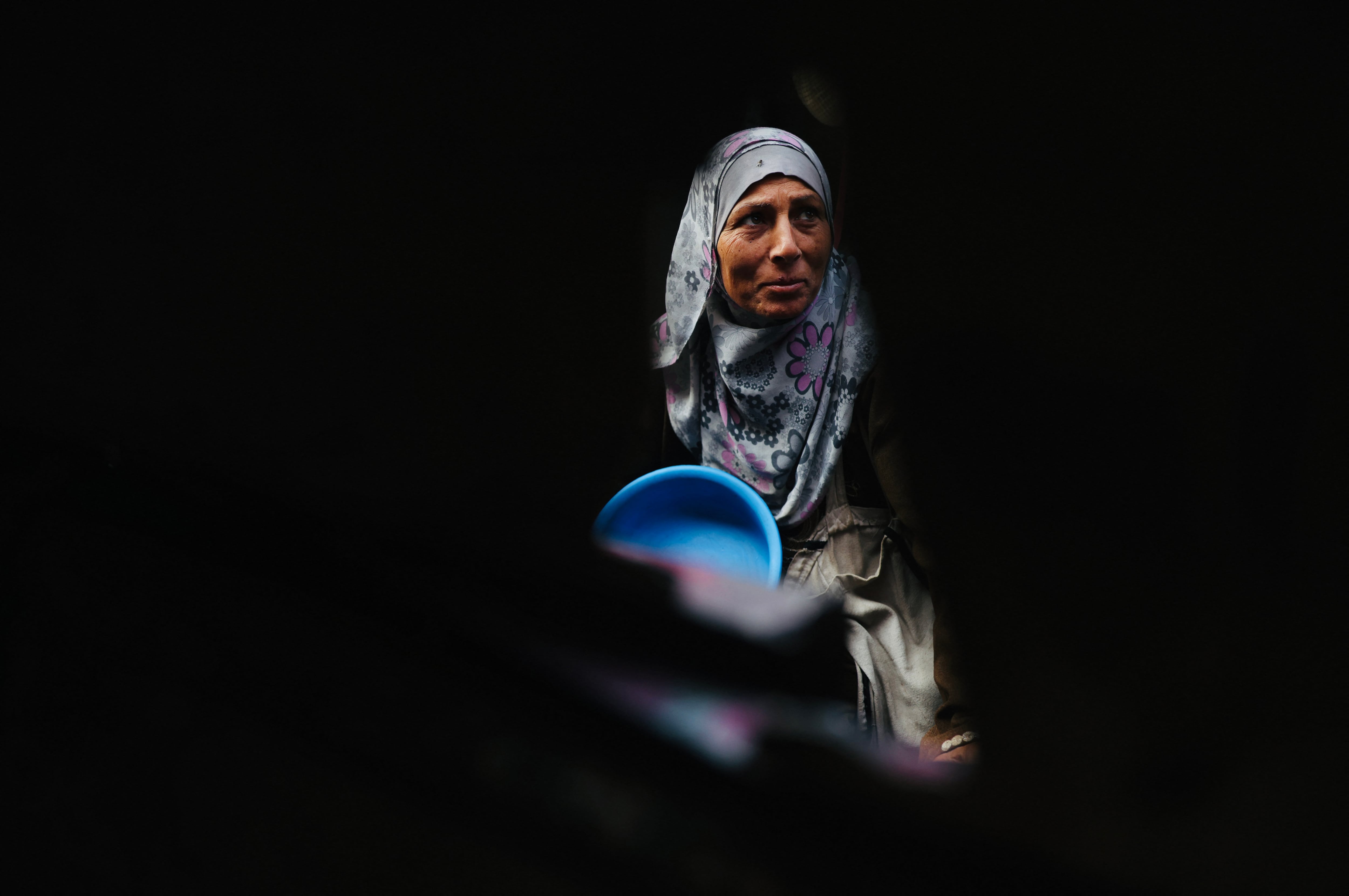 Una mujer palestina desplazada esperaba con su contenedor para recibir porciones de comida donadas en un comedor social en Khan Yunis, al sur de la Franja de Gaza, el pasado 17 de diciembre. Fotografía:
