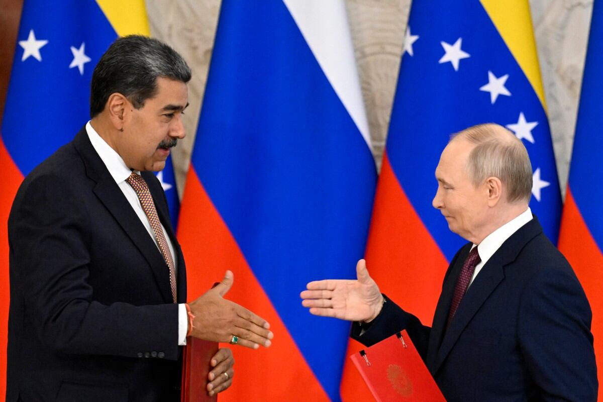 Russian President Vladimir Putin and Venezuelan President Nicolas Maduro shake hands as they exchange documents during a signing ceremony following their talks at the Kremlin in Moscow on May 7, 2025. (Photo by Alexander NEMENOV / AFP)