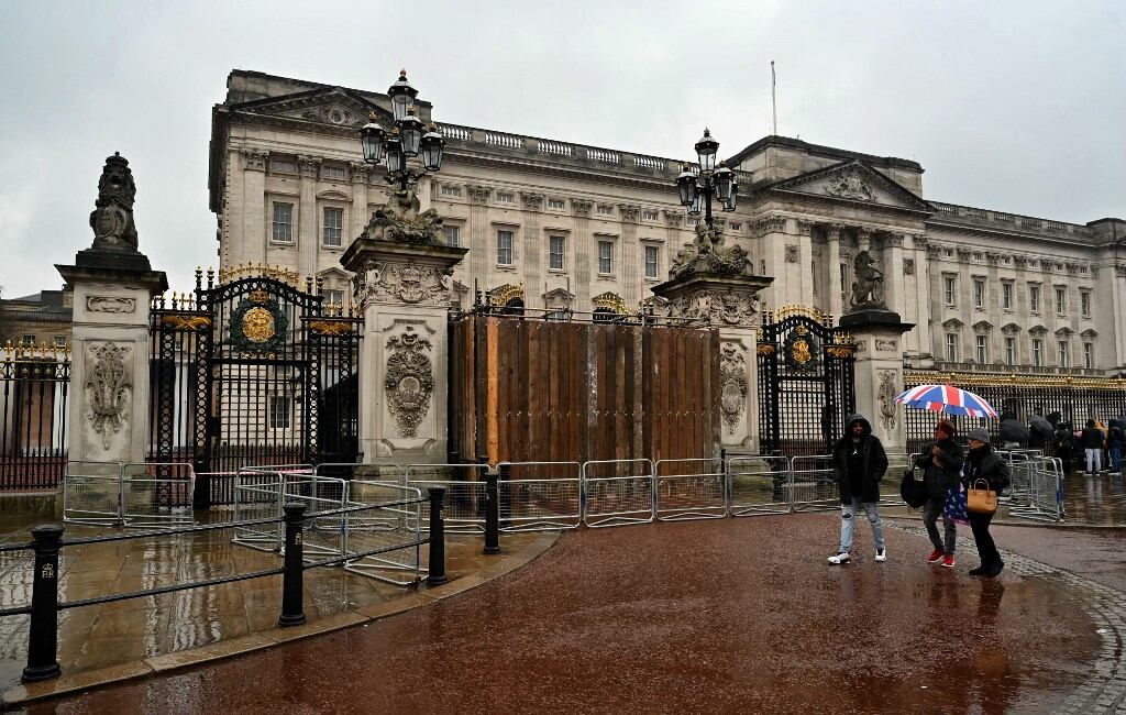 Peatones junto a portones del Palacio de Buckingham en Londres este 10 de marzo de 2024, en el punto por donde un automóvil chocó contra ese acceso al palacio real. Fotografía: AFP.