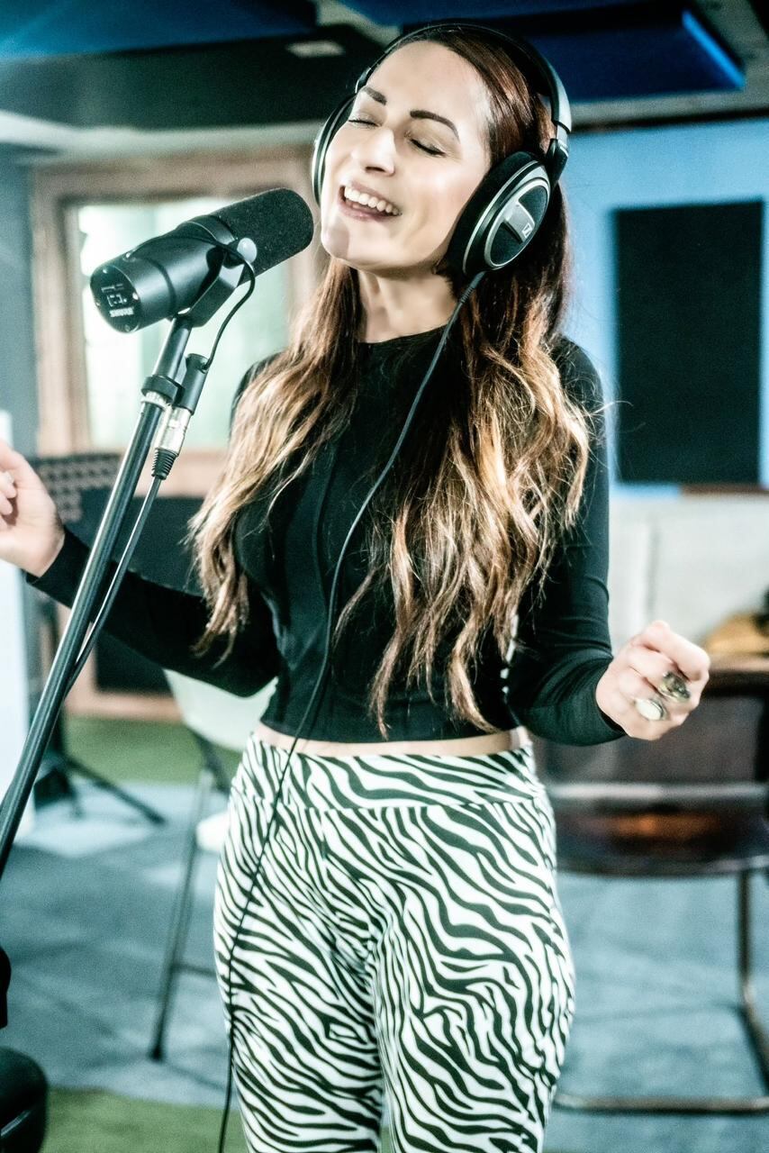 Cantantes interpretando canciones en la grabación en un estudio.