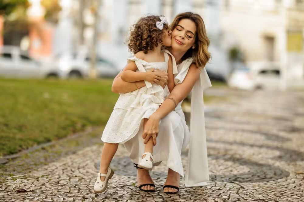 Ana Luiza Prestes abraza a su hija Cecília después de completar su tratamiento contra el carcinoma adenoide quístico, un cáncer raro de las glándulas salivares. Madre e hija comparten un emotivo momento tras la recuperación.